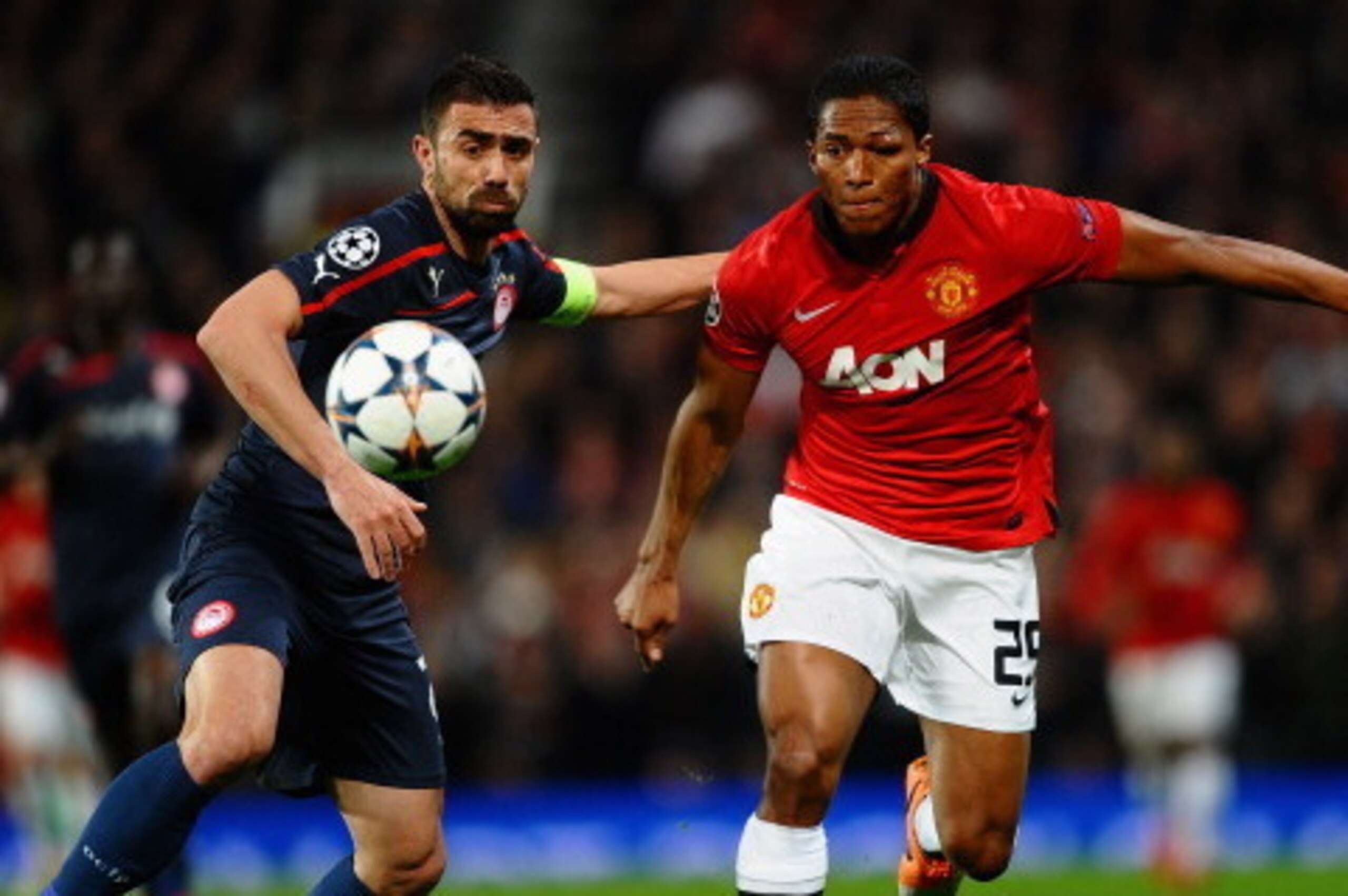 MANCHESTER, ENGLAND - MARCH 19:  Antonio Valencia of Manchester United competes with Giannis Maniatis of Olympiacos during the UEFA Champions League Round of 16 second round match between Manchester United and Olympiacos FC at Old Trafford on March 19, 20
