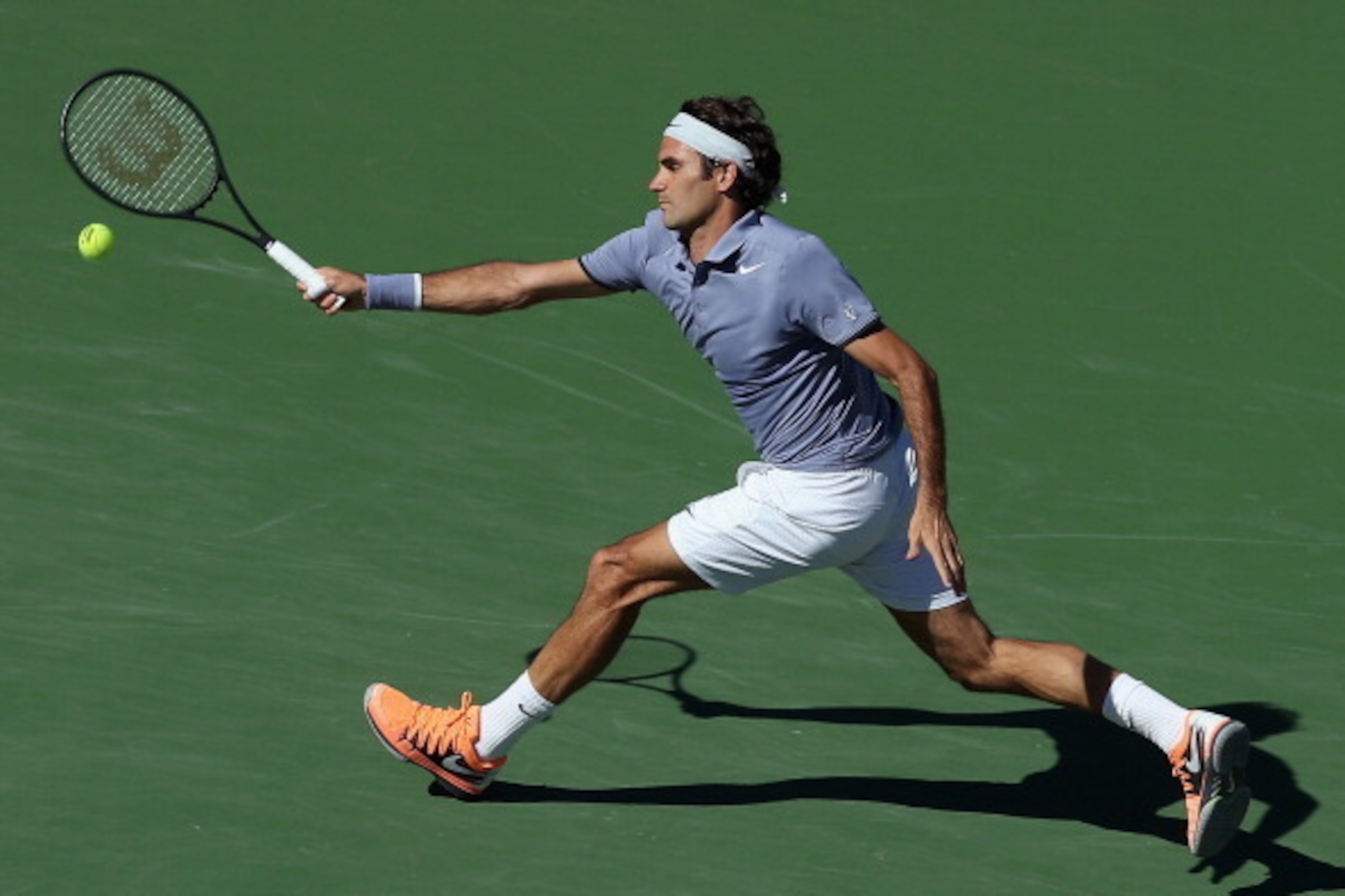 INDIAN WELLS, CA - MARCH 16:  Roger Federer of Switzerland lunges to return a forehand to Novac Djokovic of Serbia during the final of the BNP Paribas Open at Indian Wells Tennis Garden on March 16, 2014 in Indian Wells, California.  (Photo by Jeff Gross/