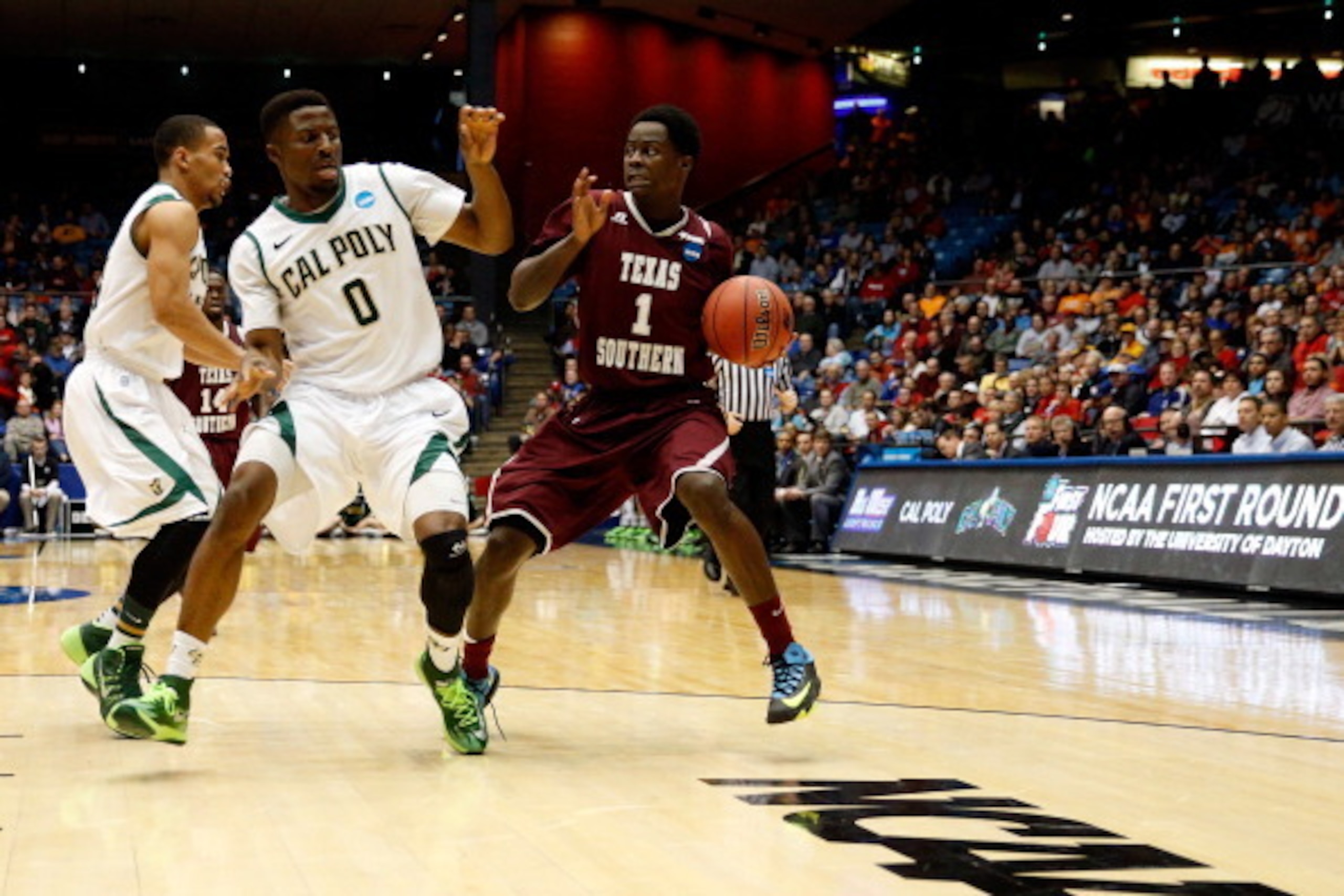 DAYTON, OH - MARCH 19: D.D. Scarver #1 of the Texas Southern Tigers carries the ball as Dave Nwaba #0 of the Cal Poly Mustangs defends during the first round of the 2014 NCAA Men's Basketball Tournament at UD Arena on March 19, 2014 in Dayton, Ohio.  (Pho