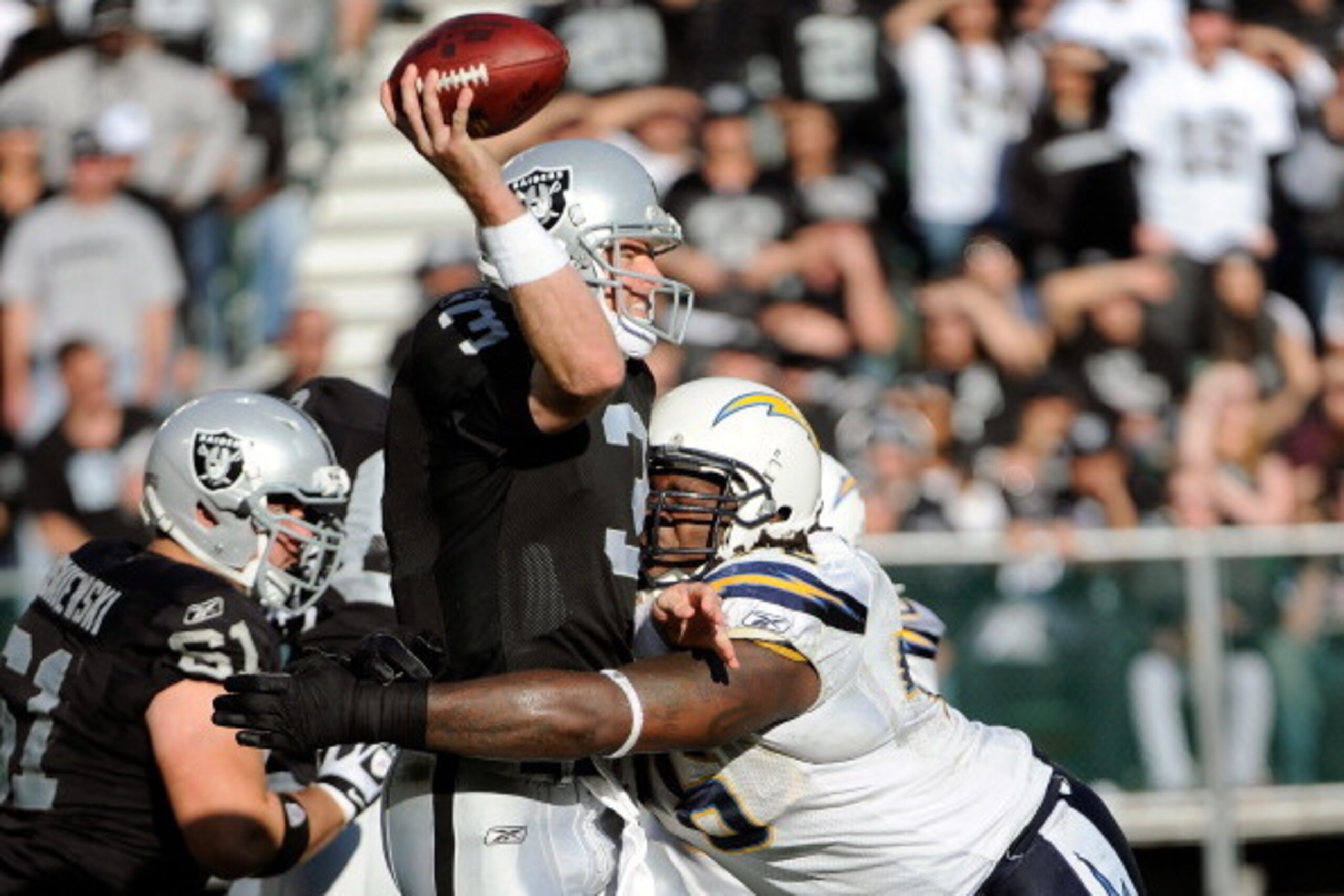 OAKLAND, CA - JANUARY 01:  Carson Palmer #3 of the Oakland Raiders gets his pass off under pressure from Cam Thomas #76 of the San Diego Chargers at O.co Coliseum on January 1, 2012 in Oakland, California.  (Photo by Thearon W. Henderson/Getty Images)