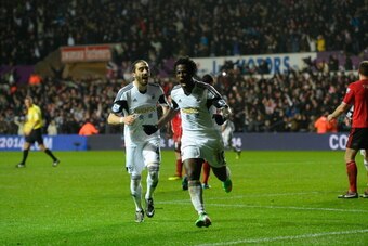 SWANSEA, WALES - FEBRUARY 08:  Swansea striker Wilfried Bony (r) celebrates with Chico Flores after scoring the third goal during the Barclays Premier League match between Swansea City and Cardiff City at Liberty Stadium on February 8, 2014 in Swansea, Wa