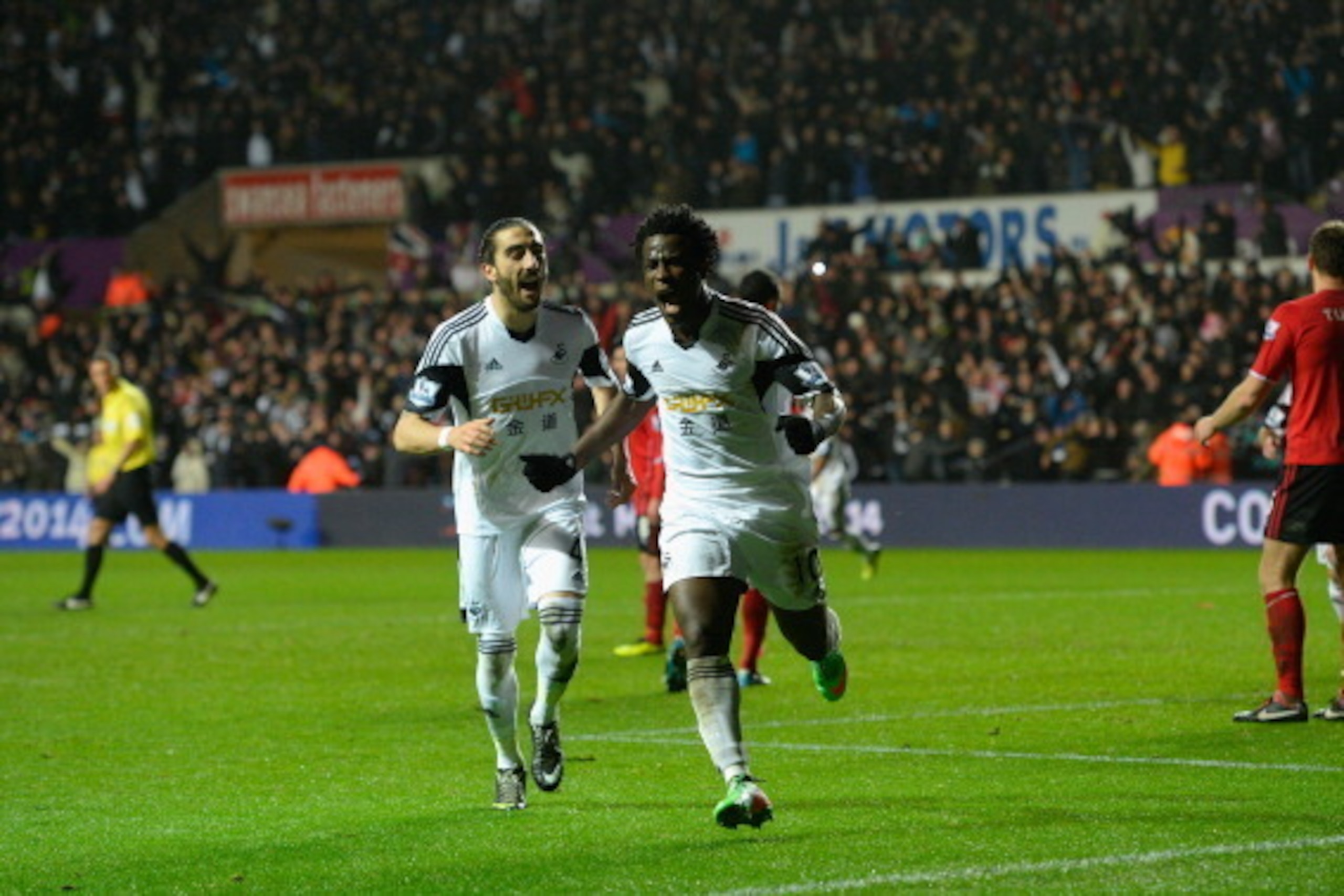 SWANSEA, WALES - FEBRUARY 08:  Swansea striker Wilfried Bony (r) celebrates with Chico Flores after scoring the third goal during the Barclays Premier League match between Swansea City and Cardiff City at Liberty Stadium on February 8, 2014 in Swansea, Wa