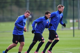 ST ALBANS, ENGLAND - NOVEMBER 25:  Lukas Podolski, Mesut Ozil and Per Mertesacker of Arsenal warm up during a training session at London Colney on November 25, 2013 in St Albans, England.  (Photo by Shaun Botterill/Getty Images)
