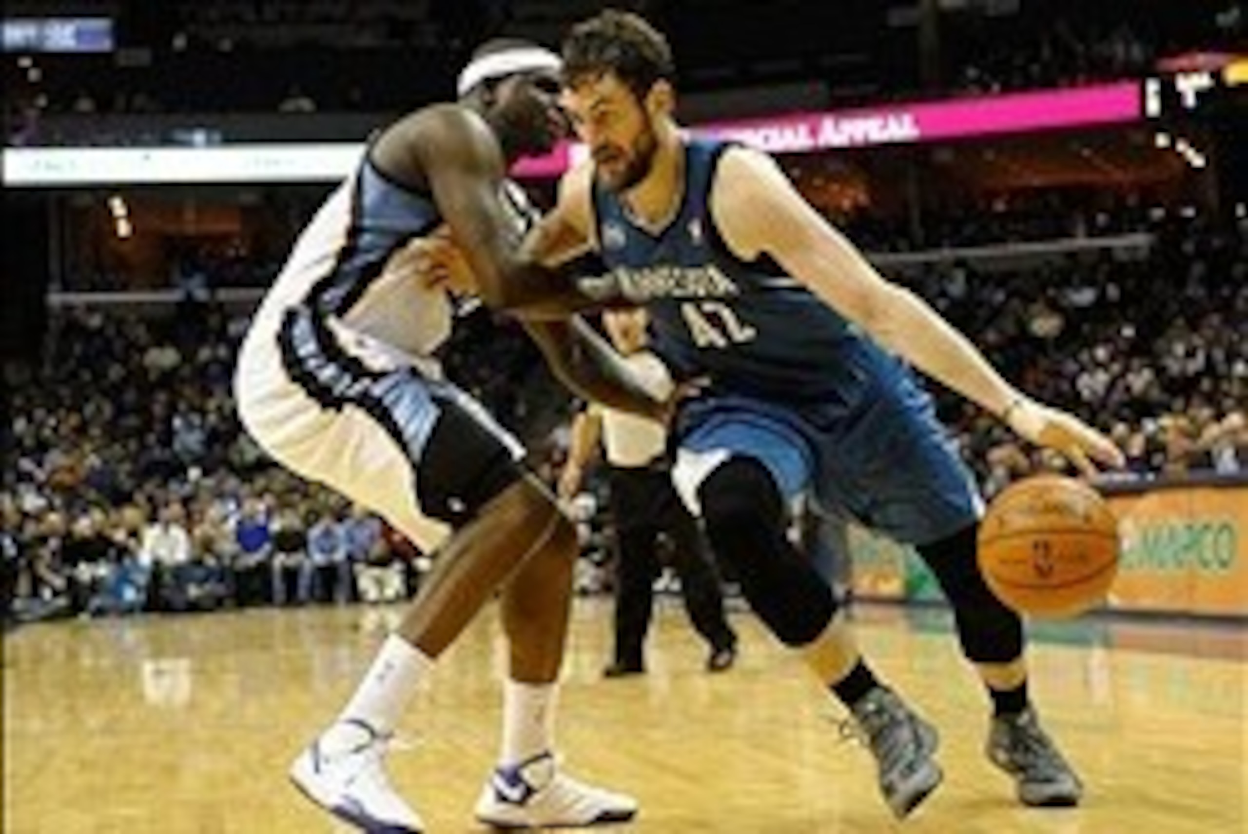 Dec 15, 2013; Memphis, TN, USA; Minnesota Timberwolves power forward Kevin Love (42) dribbles the ball as Memphis Grizzlies power forward Zach Randolph (50) defends during the fourth quarter at FedExForum. The Timberwolves won 101 - 93. Mandatory Credit: 