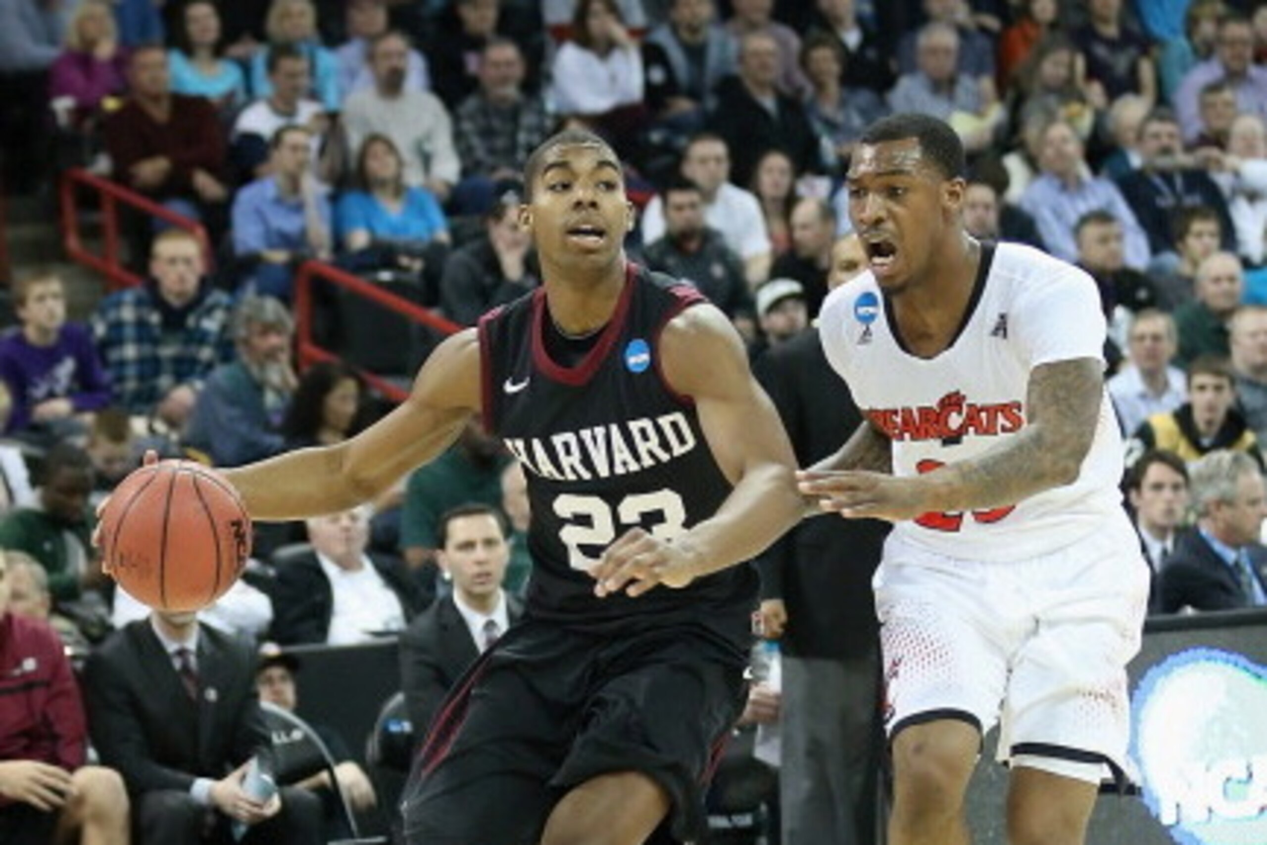 SPOKANE, WA - MARCH 20:  Wesley Saunders #23 of the Harvard Crimson dribbles past Sean Kilpatrick #23 of the Cincinnati Bearcats during the second round of the 2014 NCAA Men's Basketball Tournament at Spokane Veterans Memorial Arena on March 20, 2014 in S