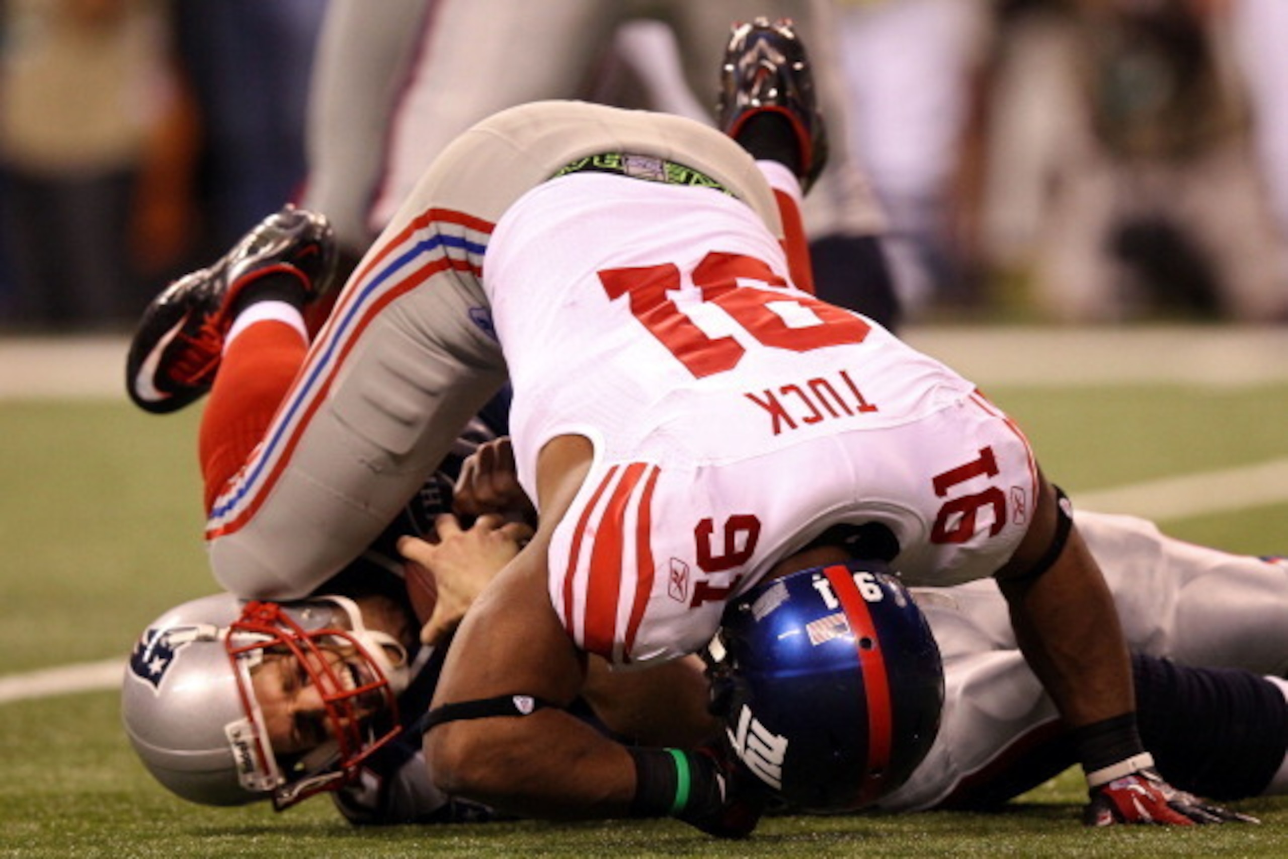 INDIANAPOLIS, IN - FEBRUARY 05:  Quarterback Tom Brady #12 of the New England Patriots is sacked by Justin Tuck #91 of the New York Giants in the second half during Super Bowl XLVI at Lucas Oil Stadium on February 5, 2012 in Indianapolis, Indiana.  (Photo