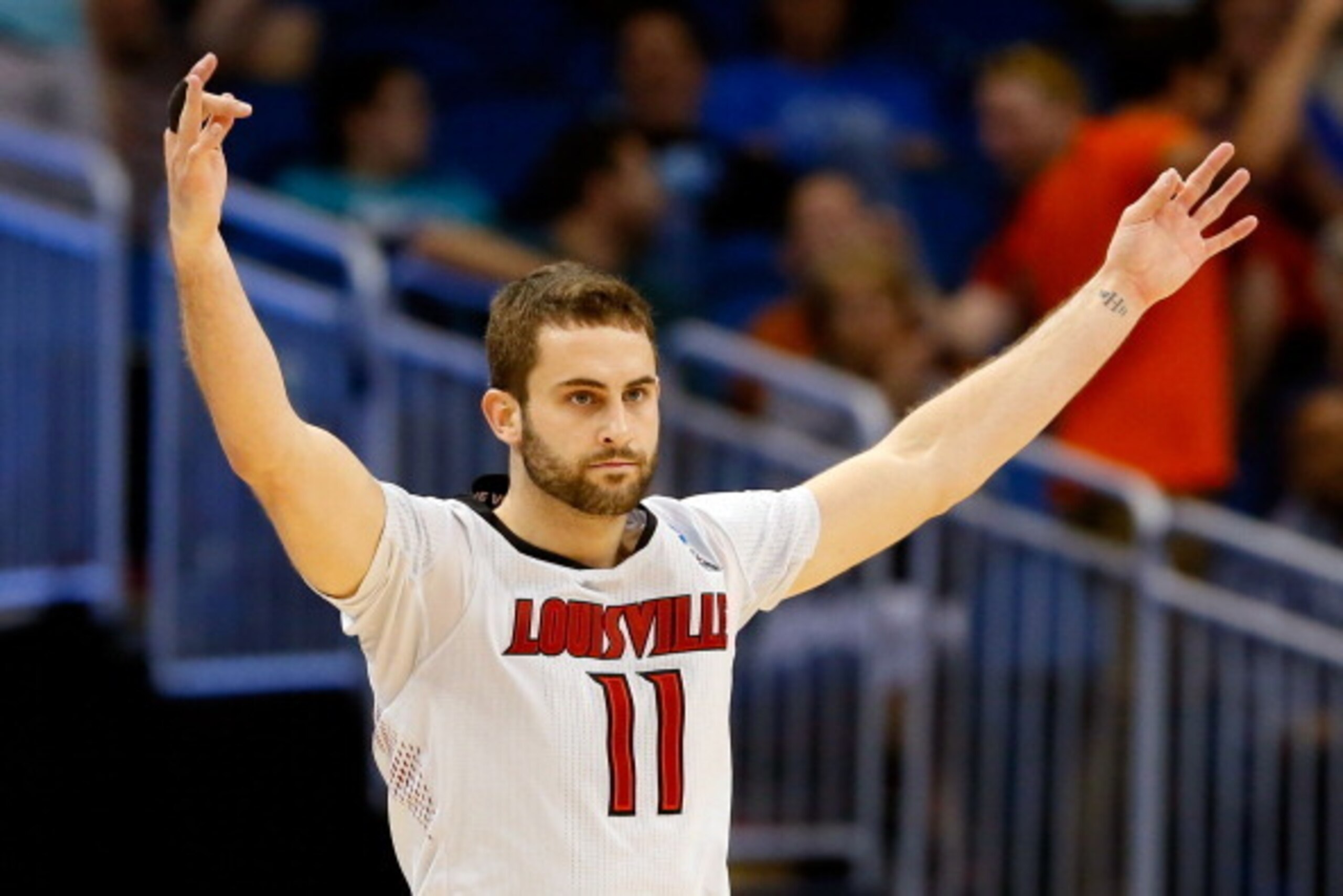 ORLANDO, FL - MARCH 20:  Luke Hancock #11 of the Louisville Cardinals celebrates after his second three point in the second half against the Manhattan Jaspers during the second round of the 2014 NCAA Men's Basketball Tournament at Amway Center on March 20