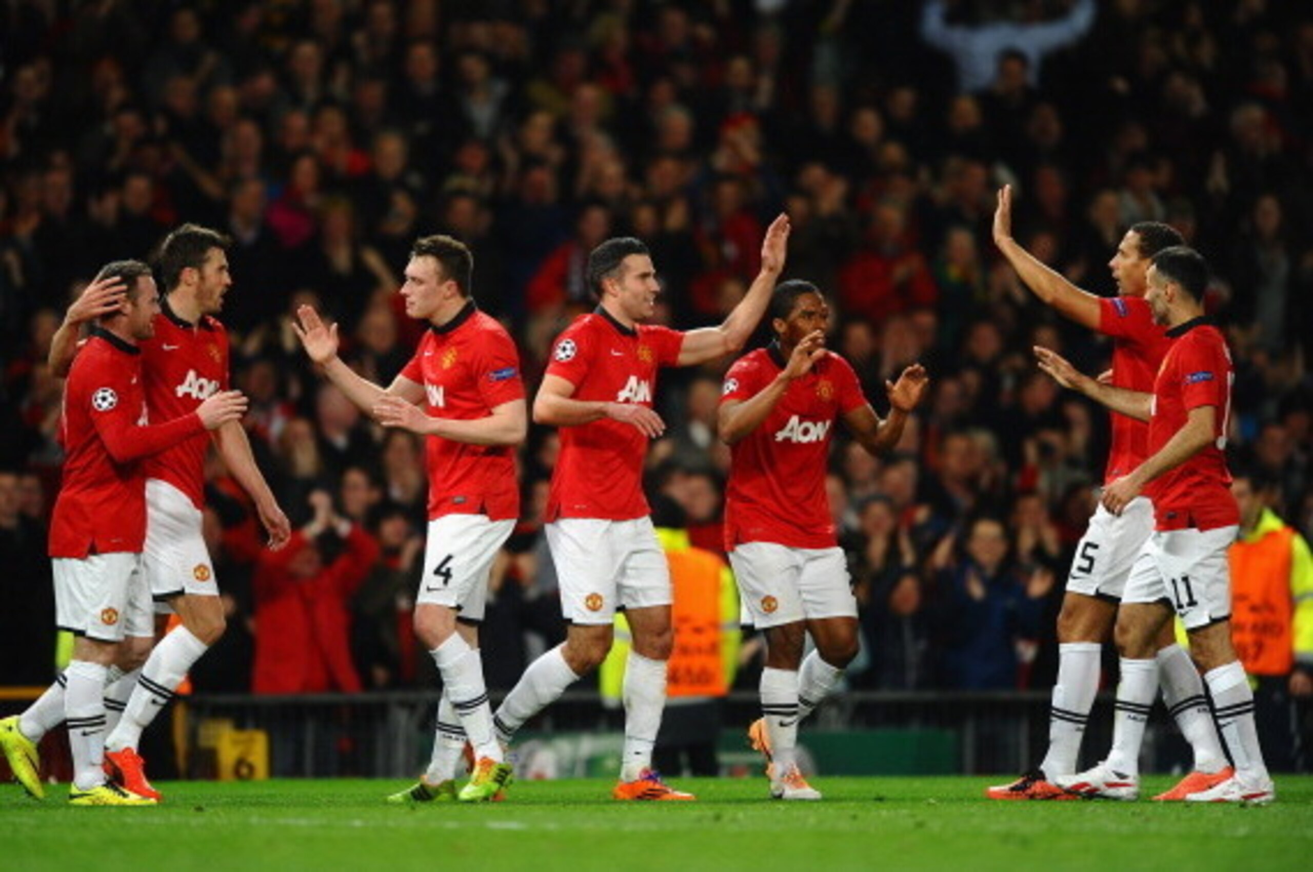MANCHESTER, ENGLAND - MARCH 19:  Robin van Persie of Manchester United celebrates scoring the second goal with his team-mates during the UEFA Champions League Round of 16 second round match between Manchester United and Olympiacos FC at Old Trafford on Ma
