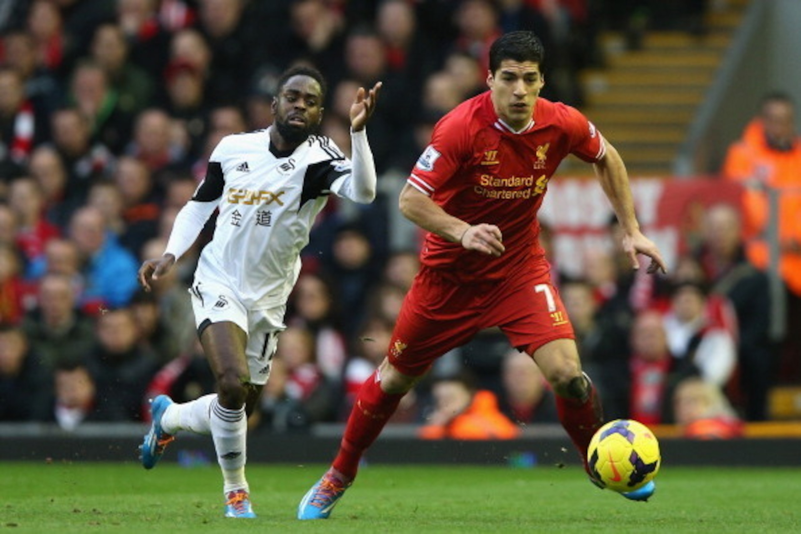 LIVERPOOL, ENGLAND - FEBRUARY 23:  Luis Suarez of Liverpool competes with Nathan Dyer of Swansea City during the Barclays Premier League match between Liverpool and Swansea City at Anfield on February 23, 2014 in Liverpool, England.  (Photo by Clive Bruns