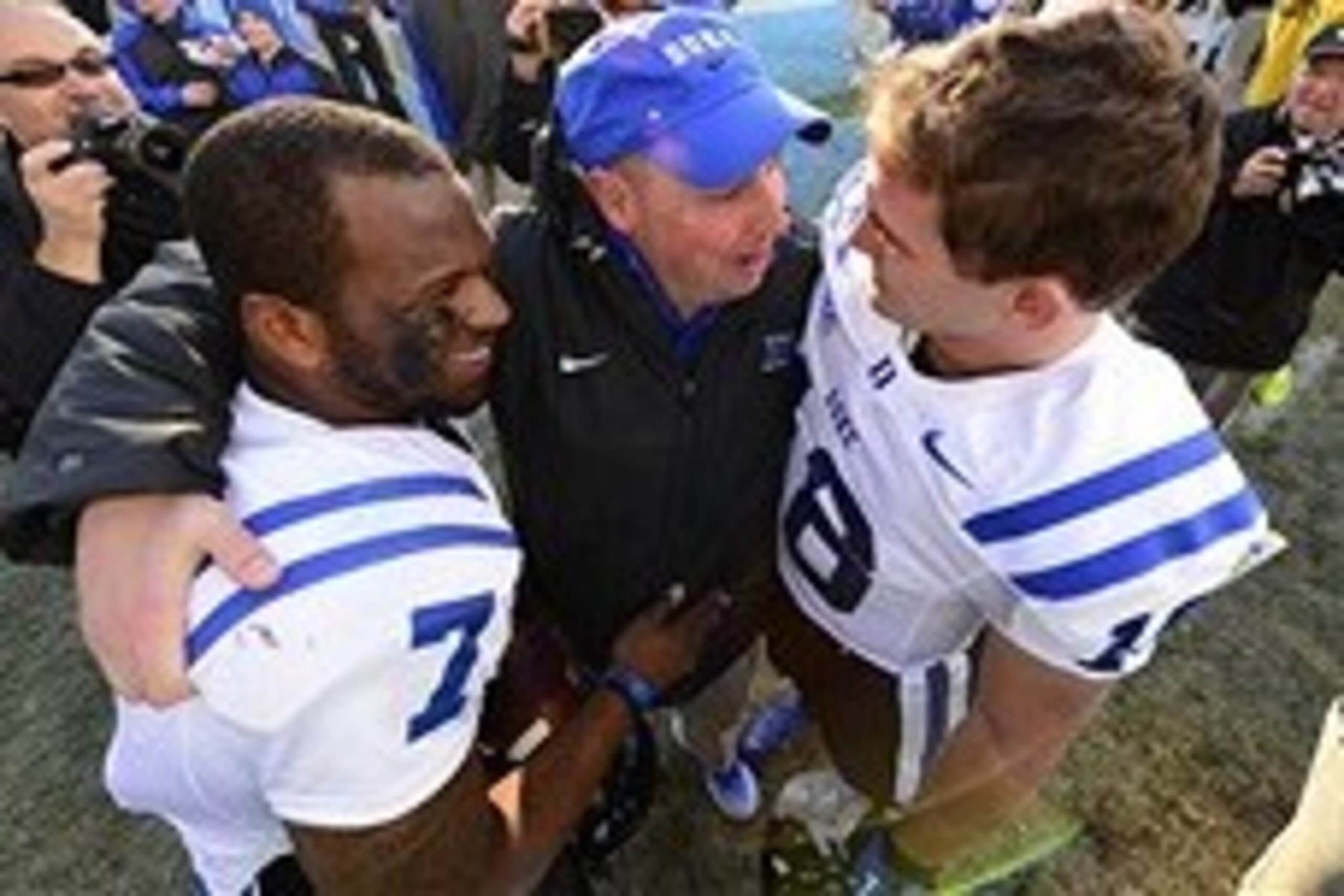Nov 30, 2013; Chapel Hill, NC, USA;  Duke Blue Devils quarterbacks Anthony Boone (7) and Brandon Connette (18) with quarterbacks coach Kurt Roper after the game. The Blue Devils defeated the North Carolina Tar Heels 27-25 at Kenan Memorial Stadium. Mandat