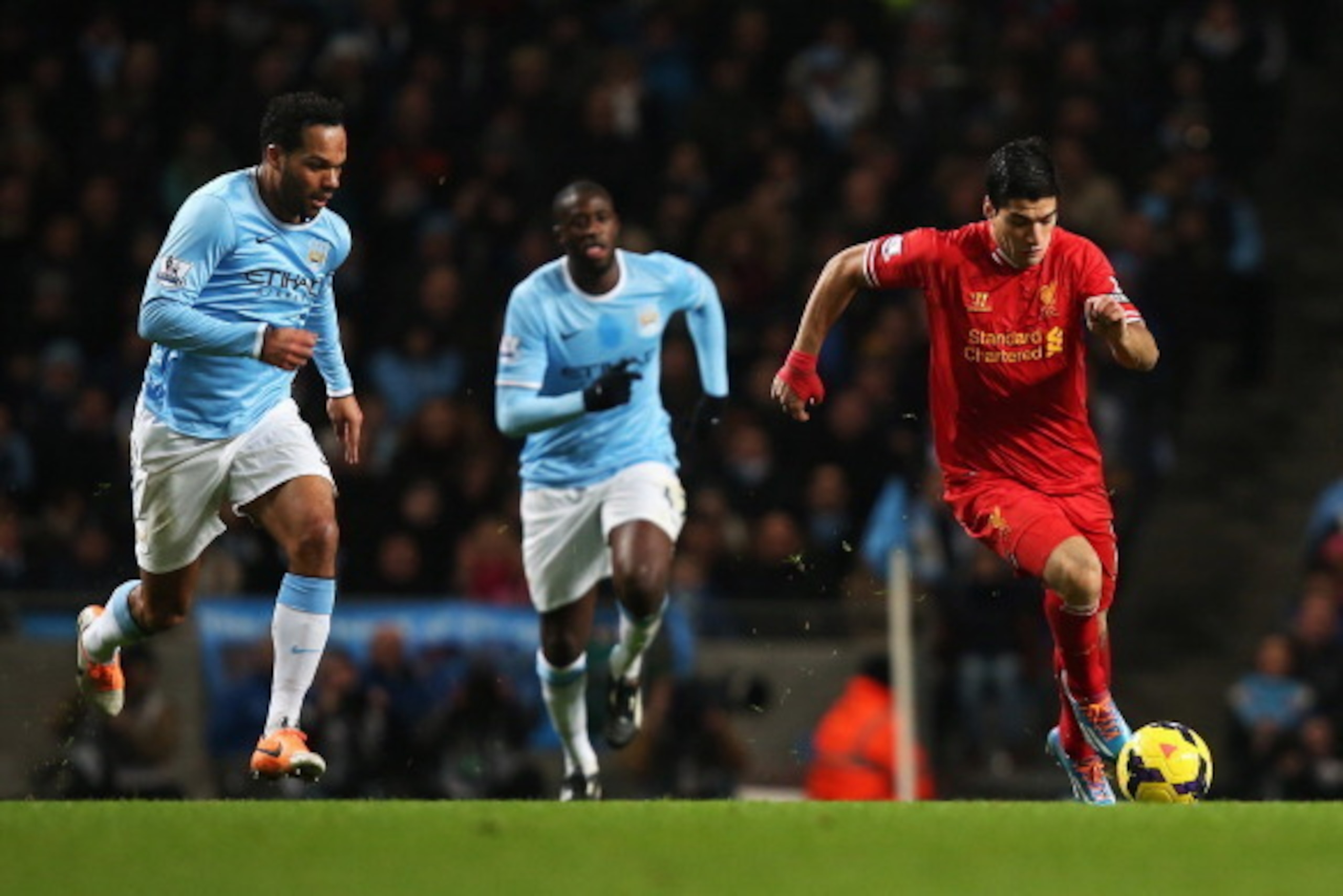MANCHESTER, ENGLAND - DECEMBER 26:  Luis Suarez of Liverpool takes on Joleon Lescott of Manchester City during the Barclays Premier League match between Manchester City and Liverpool at Etihad Stadium on December 26, 2013 in Manchester, England.  (Photo b