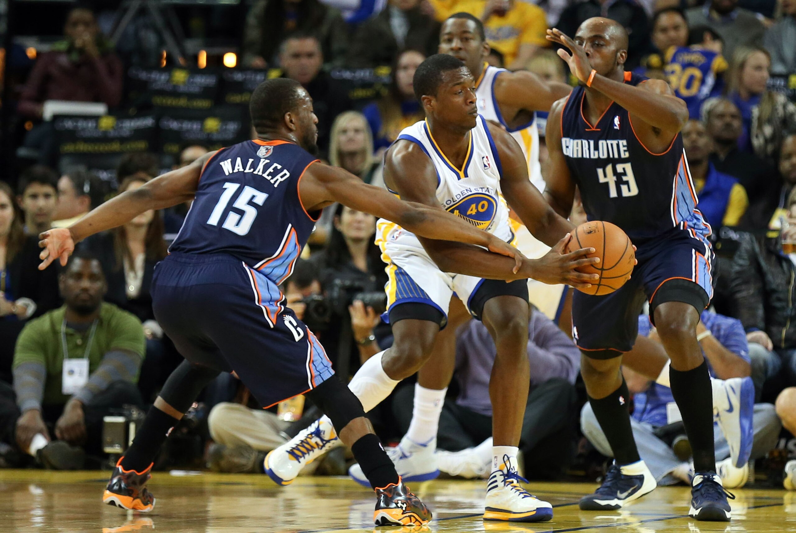 Feb 4, 2014; Oakland, CA, USA; Charlotte Bobcats point guard Kemba Walker (15) fouls Golden State Warriors small forward Harrison Barnes (40) during the second quarter at Oracle Arena. Mandatory Credit: Kelley L Cox-USA TODAY Sports