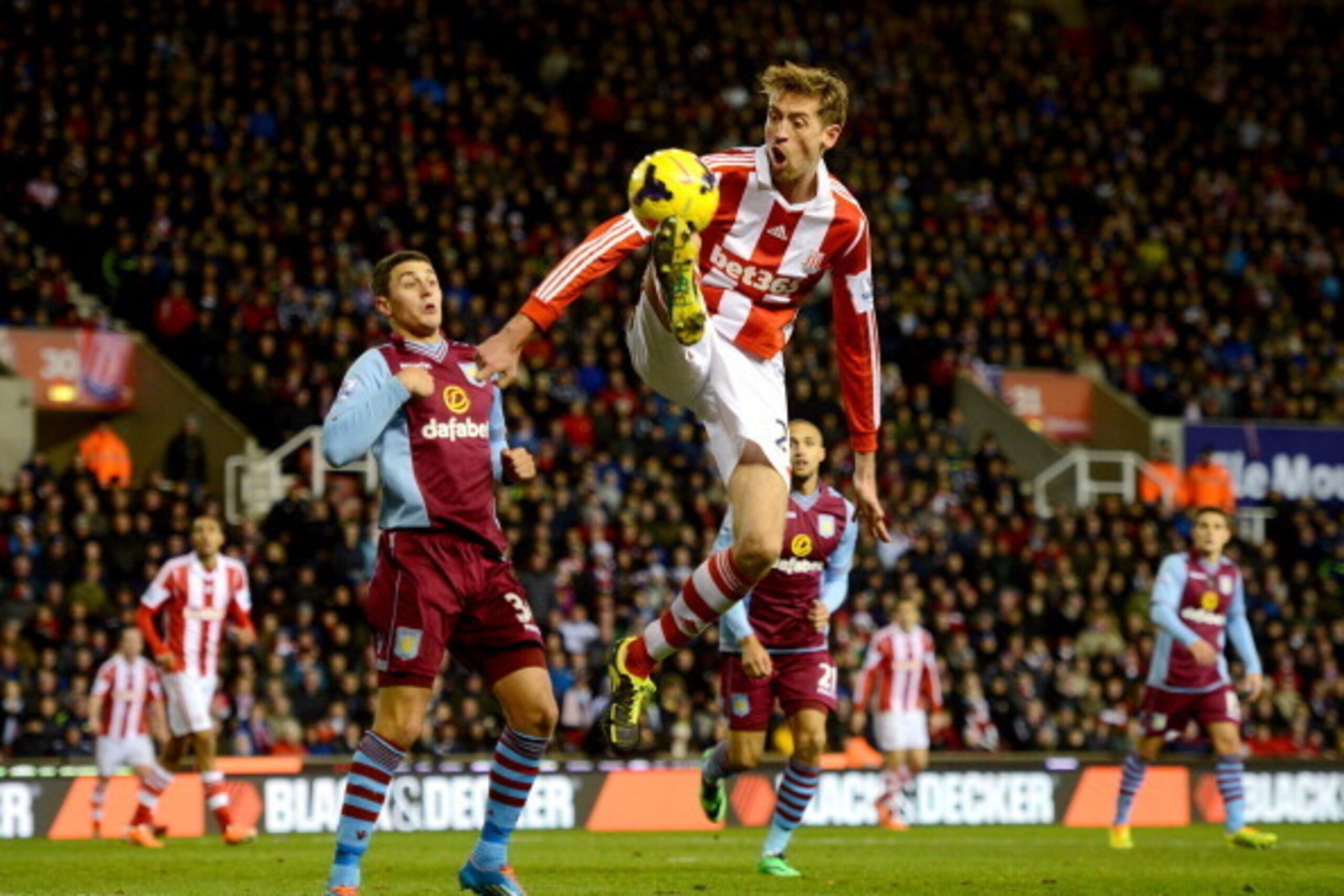 STOKE ON TRENT, ENGLAND - DECEMBER 21:  Peter Crouch of Stoke City controls the ball from Matthew Lowton of Aston Villa during the Barclays Premier League match between Stoke City and Aston Villa at Britannia Stadium on December 21, 2013 in Stoke on Trent