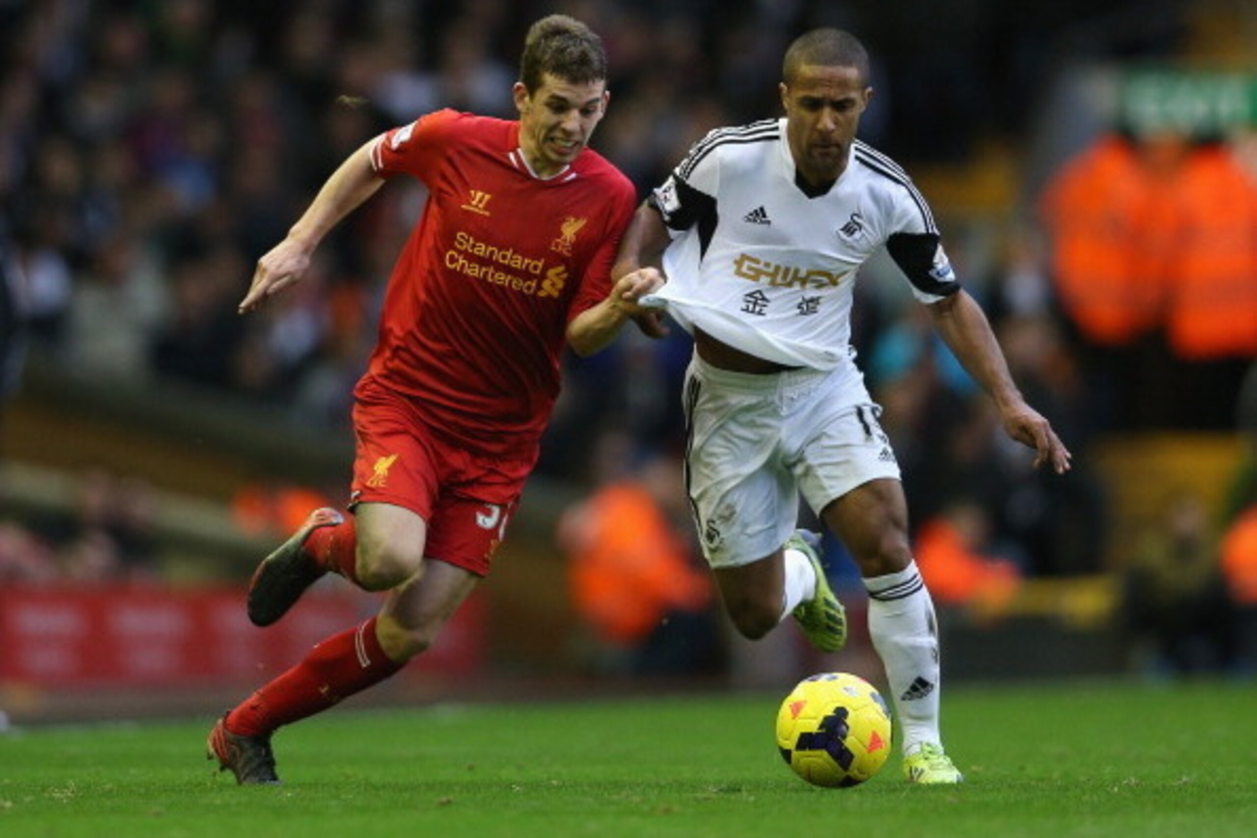 LIVERPOOL, ENGLAND - FEBRUARY 23:  Jon Flanagan of Liverpool battles with Wayne Routledge of Swansea City during the Barclays Premier League match between Liverpool and Swansea City at Anfield on February 23, 2014 in Liverpool, England.  (Photo by Clive B