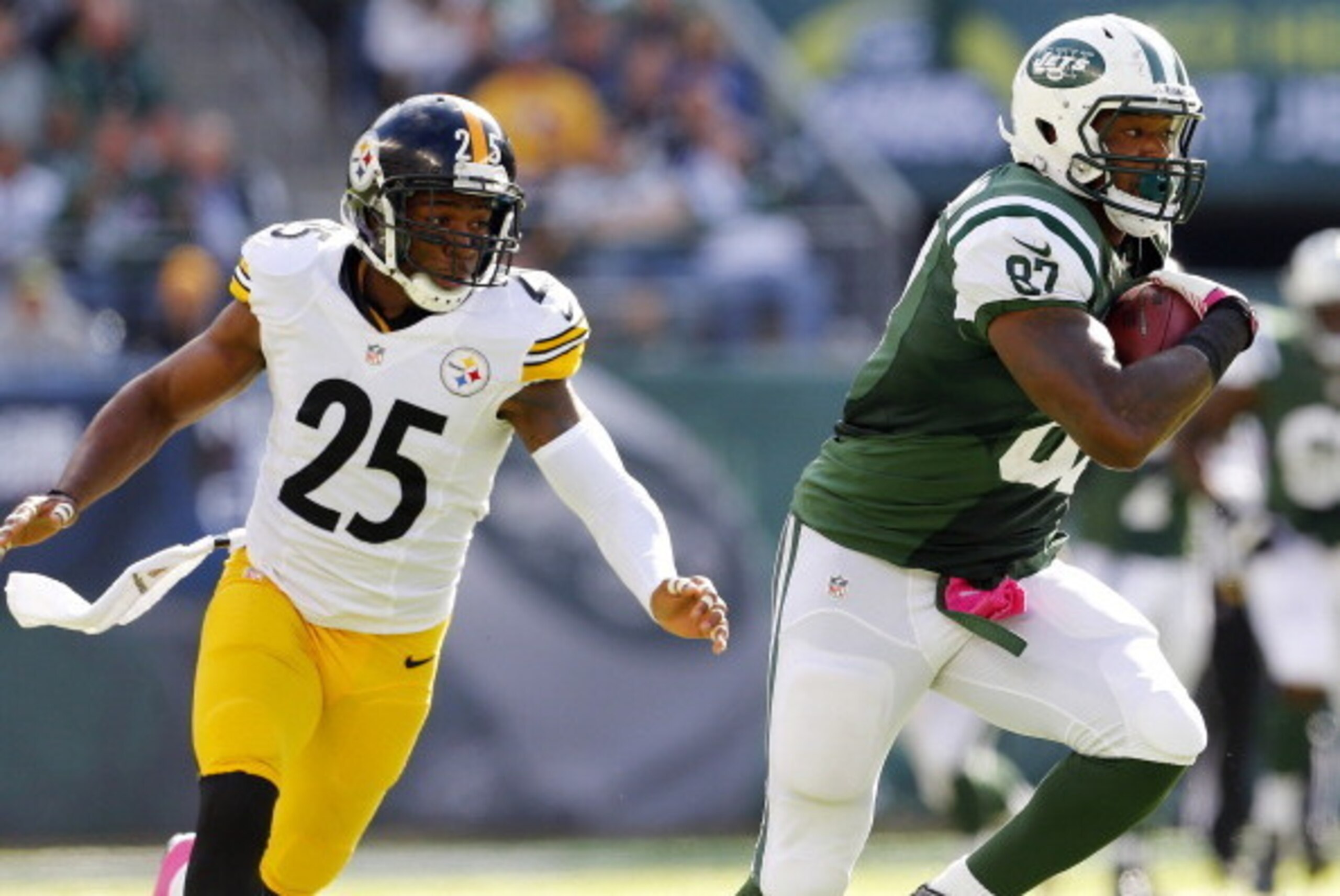EAST RUTHERFORD, NJ - OCTOBER 13: Tight end Jeff Cumberland #87 of the New York Jets attempts to outrun safety Ryan Clark #25 of the Pittsburgh Steelers after making a first down catch in the third quarter during a game at MetLife Stadium on October 13, 2