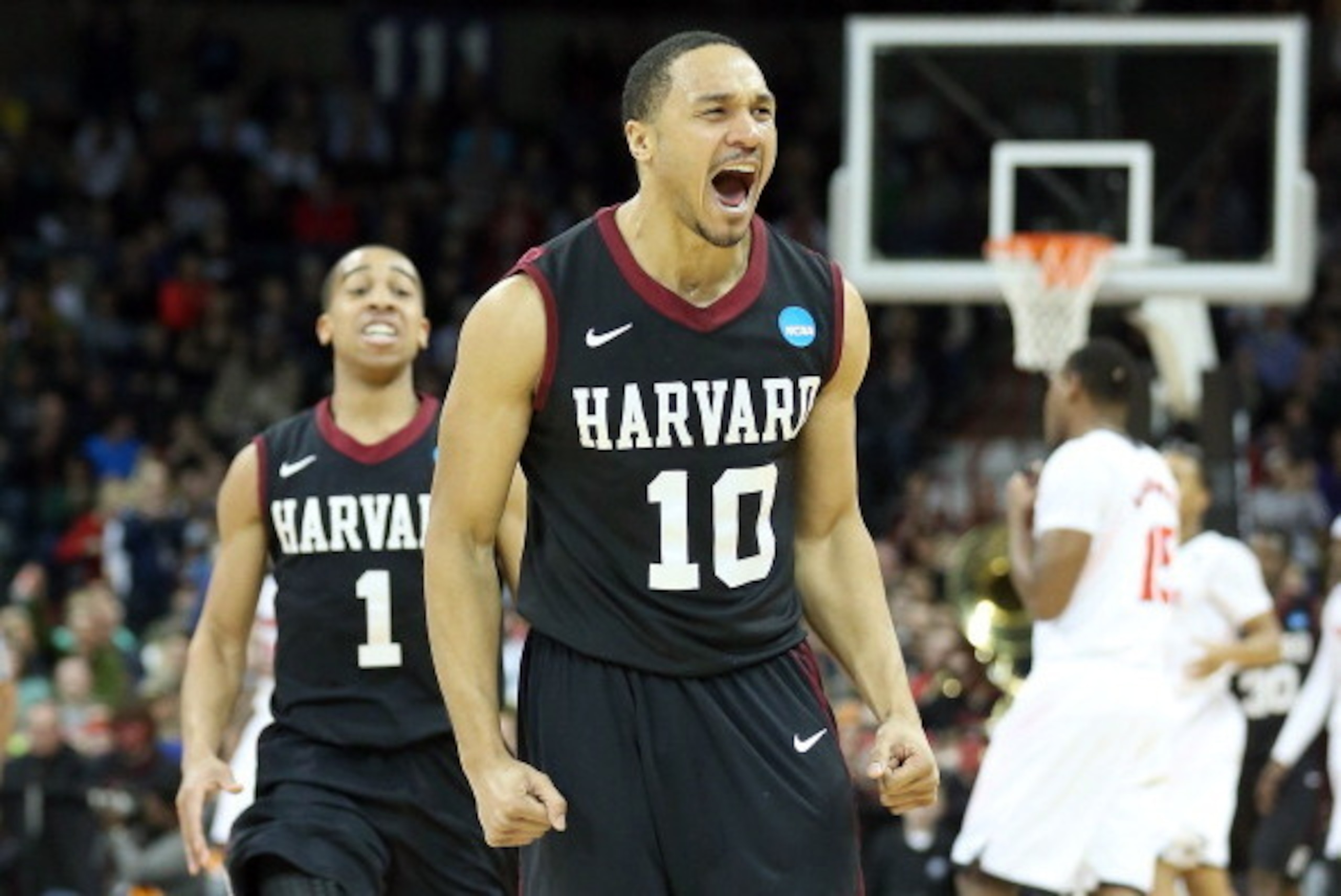 SPOKANE, WA - MARCH 20:  Brandyn Curry #10 and Siyani Chambers #1 of the Harvard Crimson celebrate after they beat the Cincinnati Bearcats during the second round of the 2014 NCAA Men's Basketball Tournament at Spokane Veterans Memorial Arena on March 20,