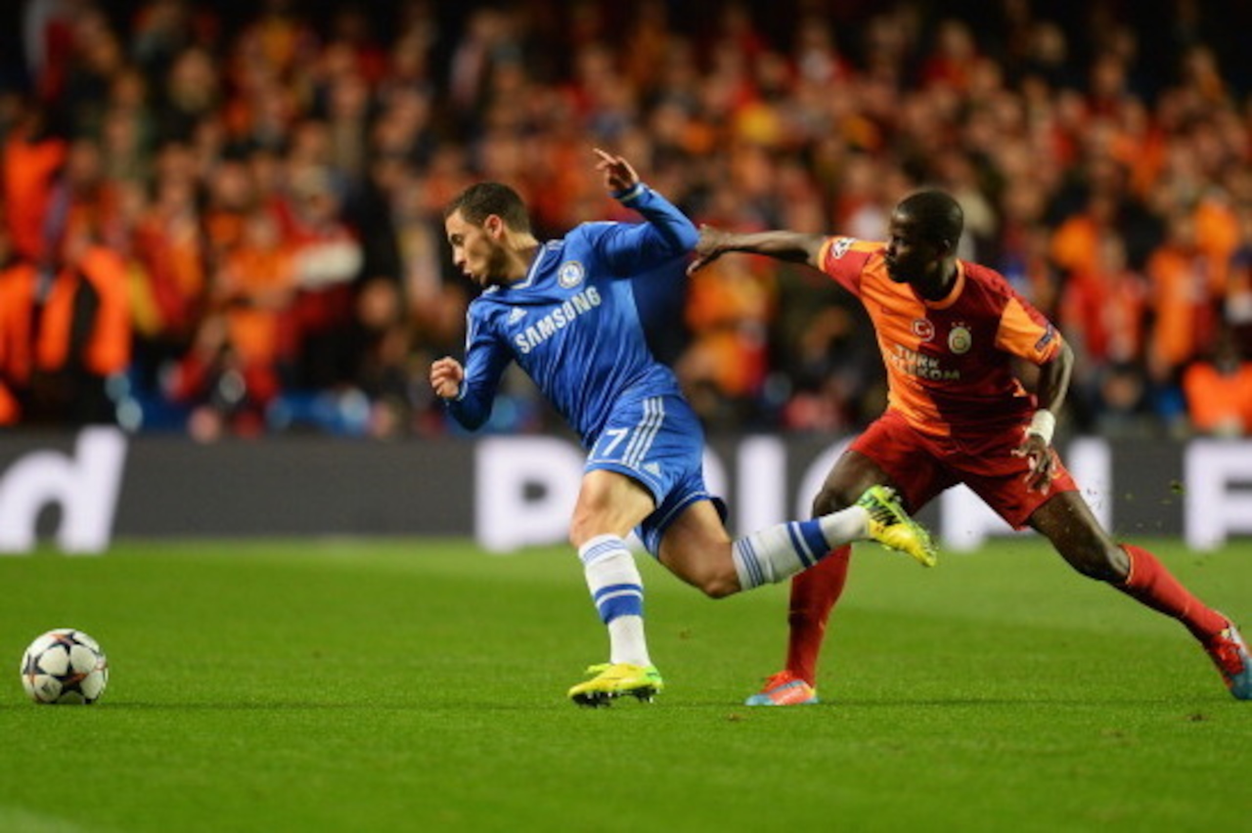 LONDON, ENGLAND - MARCH 18:  Eden Hazard of Chelsea evades Emmanuel Eboue of Galatasaray during the UEFA Champions League Round of 16 second leg match between Chelsea and Galatasaray AS at Stamford Bridge on March 18, 2014 in London, England.  (Photo by M