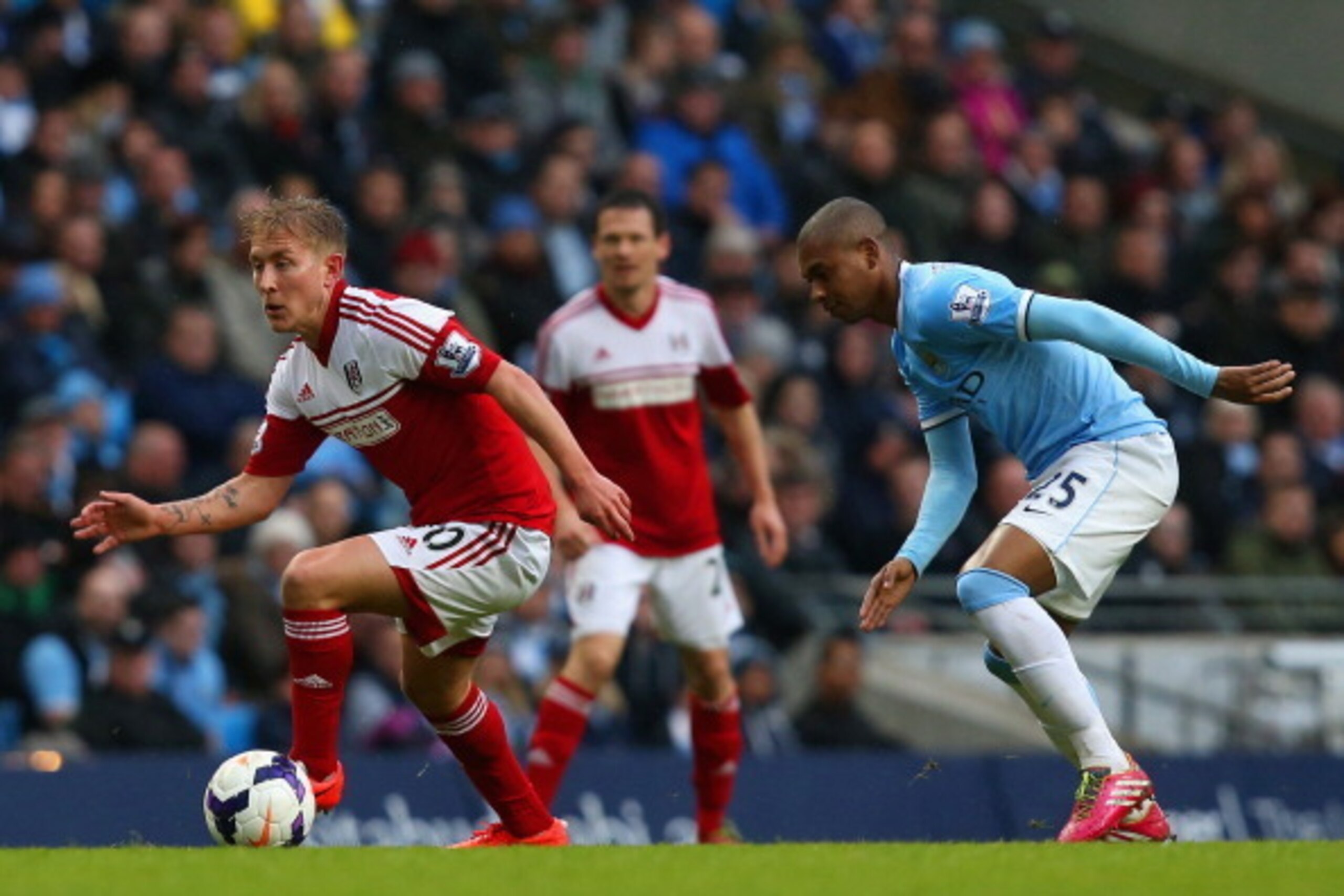 MANCHESTER, ENGLAND - MARCH 22: Lewis Holtby of Fulham is shadowed by Fernandinho of Manchester City during the Barclays Premier League match between Manchester City and Fulham at Etihad Stadium on March 22, 2014 in Manchester, England.  (Photo by Jan Kru