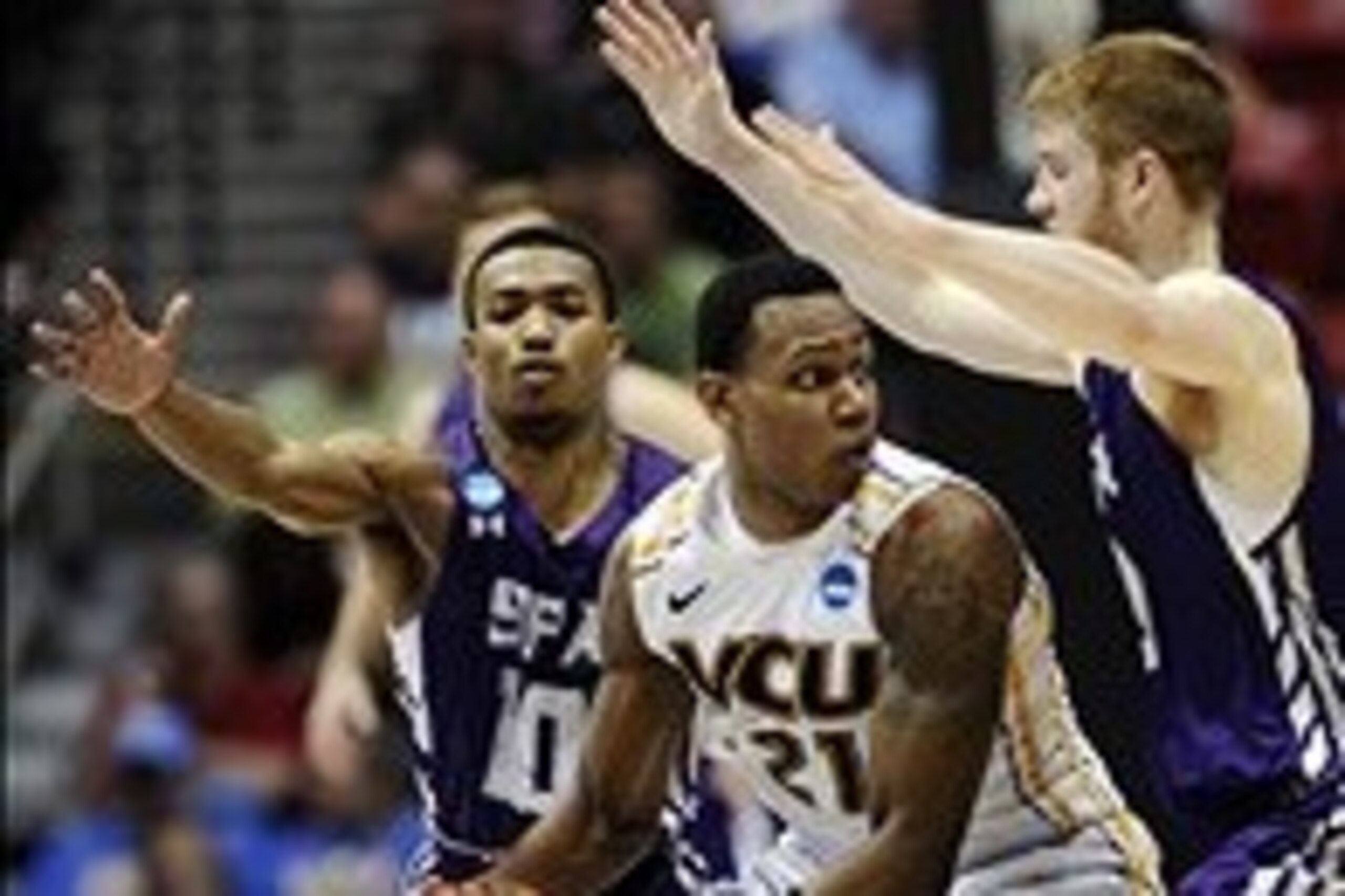 Mar 21, 2014; San Diego, CA, USA; VCU Rams guard Treveon Graham (21) is defended by Stephen F. Austin Lumberjacks guard Trey Pinkney (10) and guard Thomas Walkup in the second half of a men's college basketball game during the second round of the 2014 NCA