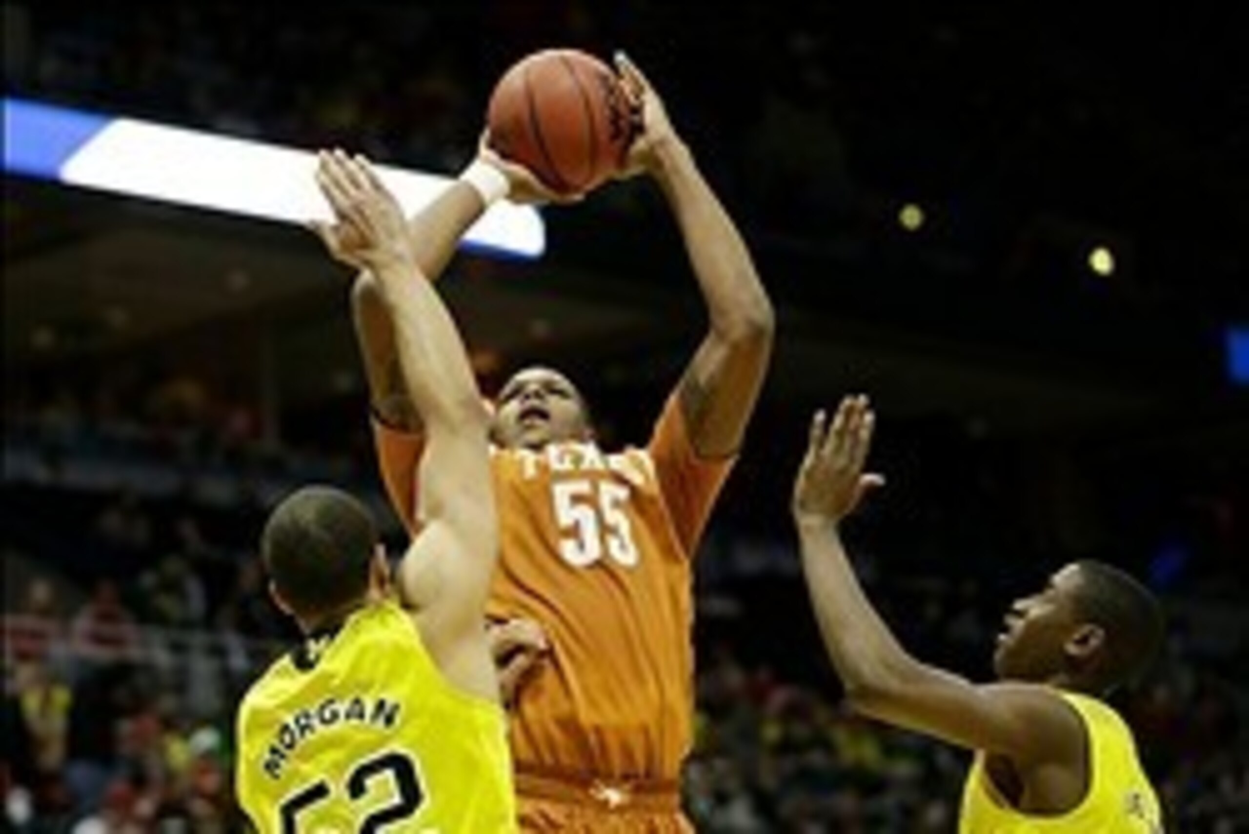 Mar 22, 2014; Milwaukee, WI, USA; Texas Longhorns center Cameron Ridley (55) shoots a jump shot over Michigan Wolverines forward Jordan Morgan (52) and guard Caris LeVert (23) in the second half of a men's college basketball game during the third round of Mar 22, 2014; Milwaukee, WI, USA; Texas Longhorns center Cameron Ridley (55) shoots a jump shot over Michigan Wolverines forward Jordan Morgan (52) and guard Caris LeVert (23) in the second half of a men's college basketball game during the third round of