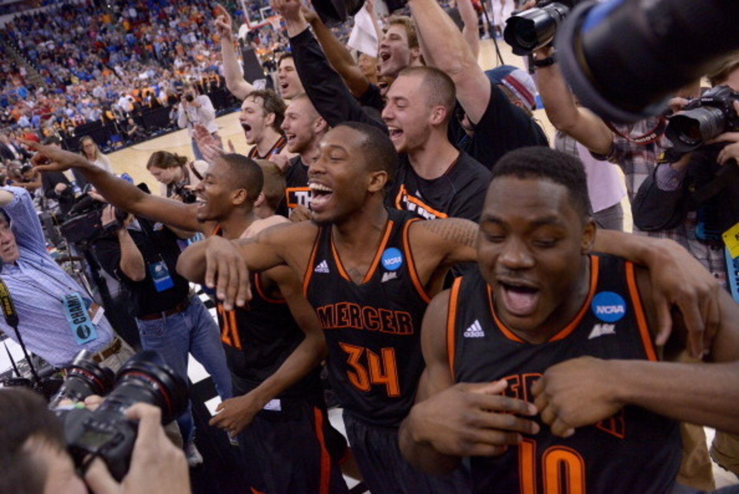 RALEIGH, NC - MARCH 21:  Jibri Bryan #34 and Ike Nwamu #10 of the Mercer Bears celebrate with teammates after defeating the Duke Blue Devils 78-71 in the second round of the 2014 NCAA Men's Basketball Tournament at PNC Arena on March 21, 2014 in Raleigh, 