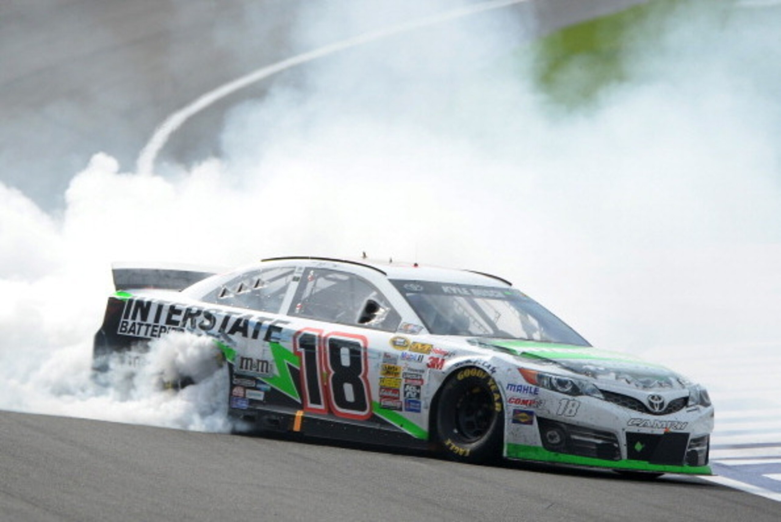 FONTANA, CA - MARCH 23:  Kyle Busch, driver of the #18 Interstate Batteries Toyota, celebrates with a burnout after winning the NASCAR Sprint Cup Series Auto Club 400 at Auto Club Speedway on March 23, 2014 in Fontana, California.  (Photo by Harry How/Get