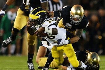 SOUTH BEND, IN - SEPTEMBER 22:  Quarterback Denard Robinson #16 of the Michigan Wolverines is tackled by cornerback Bennett Jackson #2 of the Notre Dame Fighting Irish in the first quarter at Notre Dame Stadium on September 22, 2012 in South Bend, Indiana