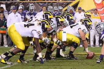 TEMPE, AZ - DECEMBER 28:  Offensive linesman Graham Glasgow #61 of the Michigan Wolverines prepares to snap the football during the Buffalo Wild Wings Bowl against the Kansas State Wildcats at Sun Devil Stadium on December 28, 2013 in Tempe, Arizona. The 