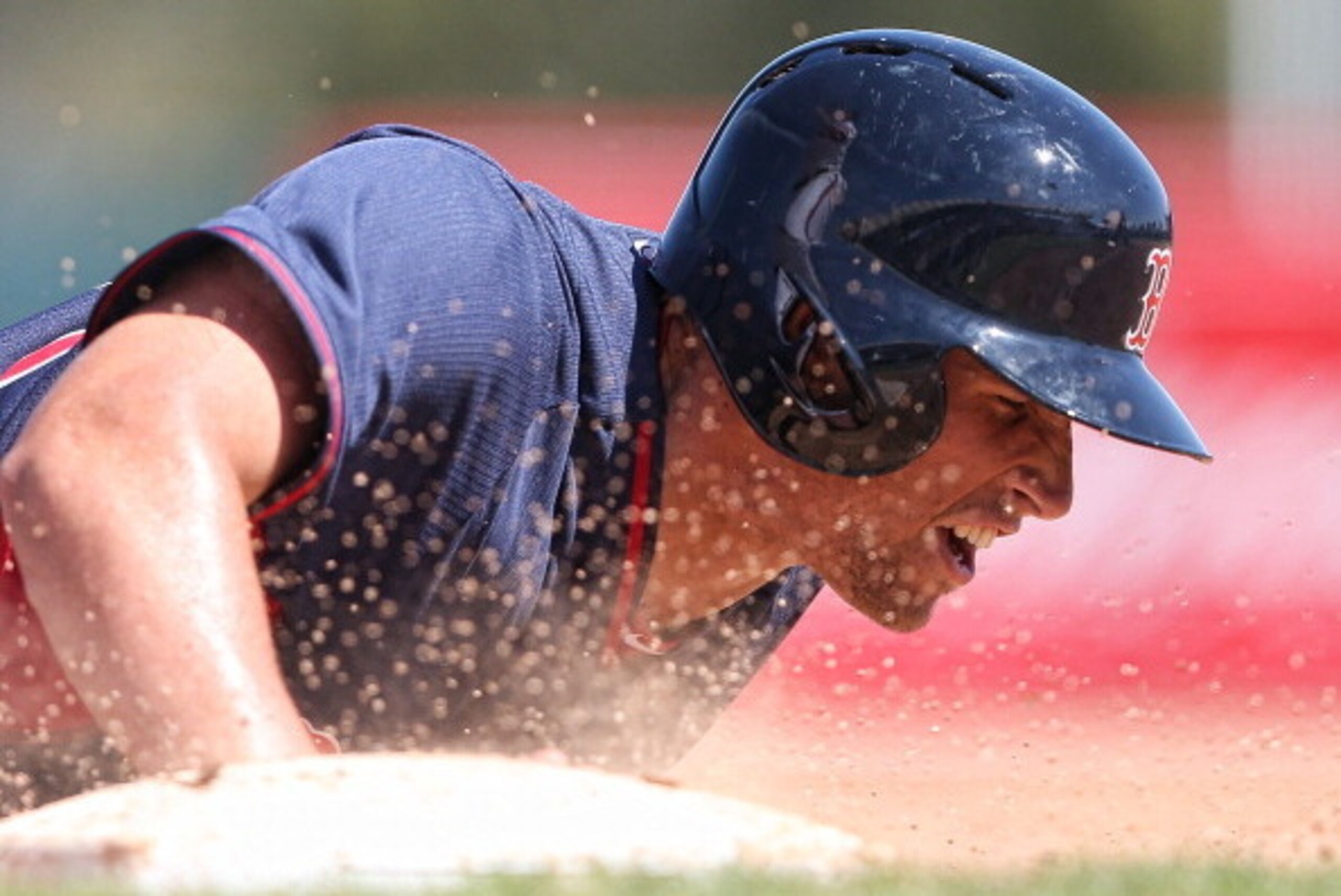 SARASOTA, FL - MARCH 11: Garin Cecchini #70 Boston Red Sox slides head first back into first base during the seventh inning of the game against the Baltimore Orioles at Ed Smith Stadium on March 11, 2014 in Sarasota, Florida. The Red Sox defeated the Orio