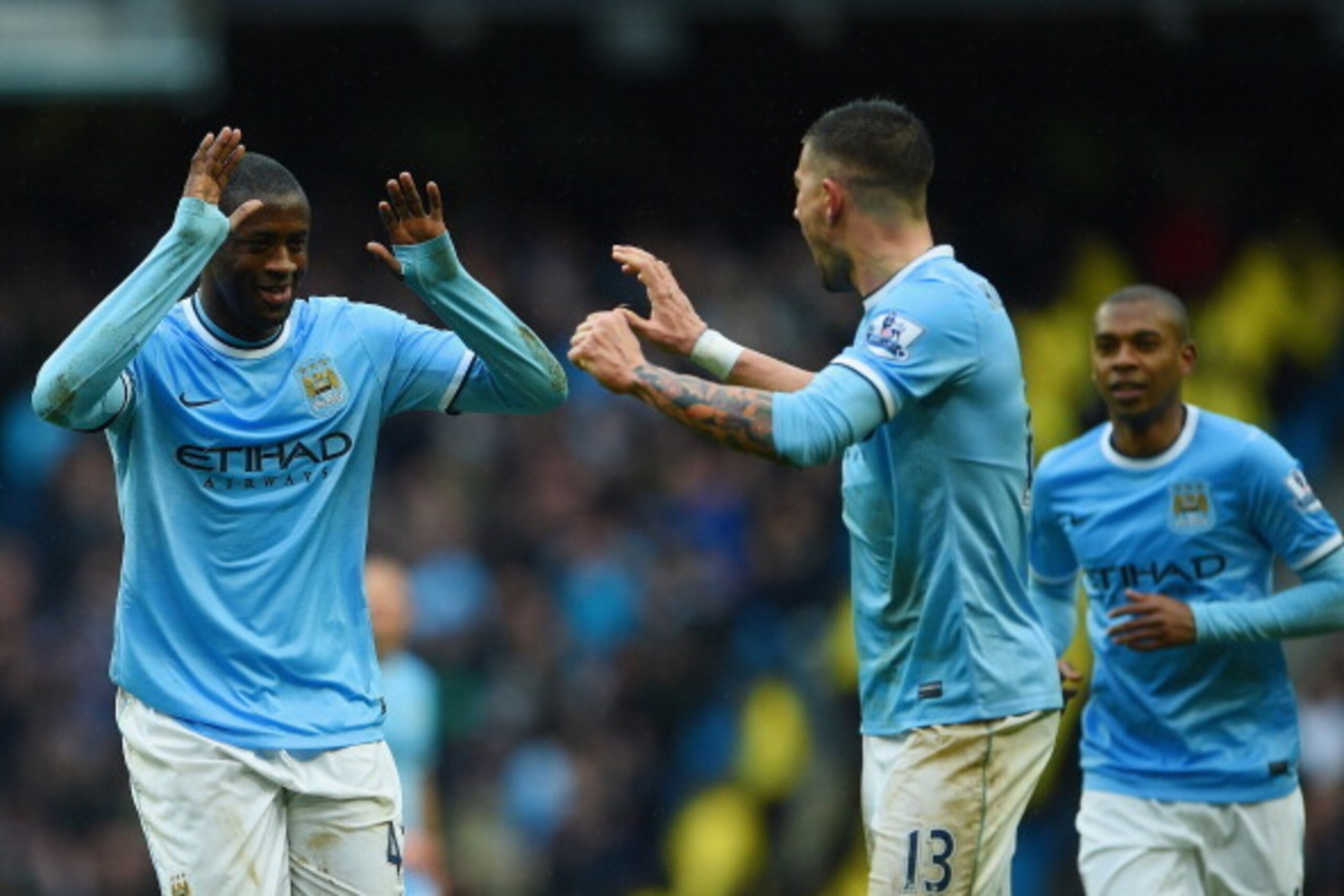 MANCHESTER, ENGLAND - MARCH 22:  Yaya Toure of Manchester City celebrates scoring his hat trick with Aleksandar Kolarov of Manchester City during the Barclays Premier League match between Manchester City and Fulham at Etihad Stadium on March 22, 2014 in M