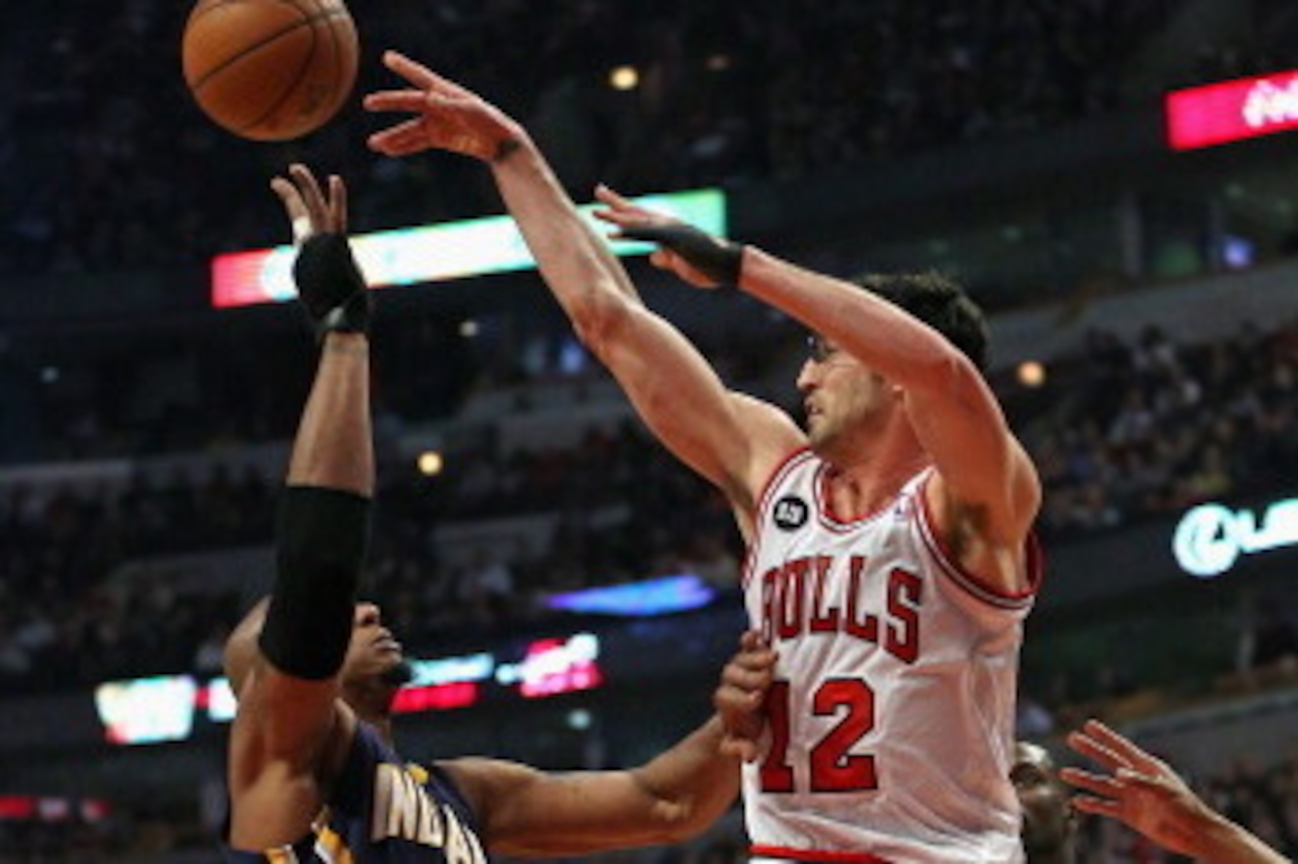 CHICAGO, IL - MARCH 24: Kirk Hinrich #12 of the Chicago Bulls leaps to pass over David West #21 of the Indiana Pacers at the United Center on March 24, 2014 in Chicago, Illinois. NOTE TO USER: User expressly acknowledges and agrees that, by downloading an