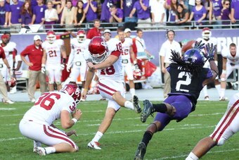 FORT WORTH, TX - DECEMBER 1: Jason Verrett #2 of the TCU Horned Frogs attempts to block Jalen Saunders #18 as he kicks the ball held by Joel Ossom #36 of the Oklahoma Sooners at Amon G. Carter Stadium on December 1, 2012 in Fort Worth, Texas. (Photo by Ri