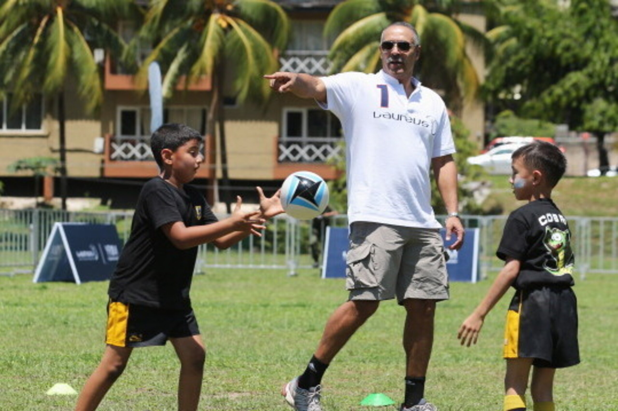 KUALA LUMPUR, MALAYSIA - MARCH 24:  Laureus Academy Member Daley Thompson interacts with players during the LWSA COBRA Rugby Project Visit ahead of the Laureus World Sports Awards at Padang Timur on March 24, 2014 in Kuala Lumpur, Malaysia.  (Photo by Ian