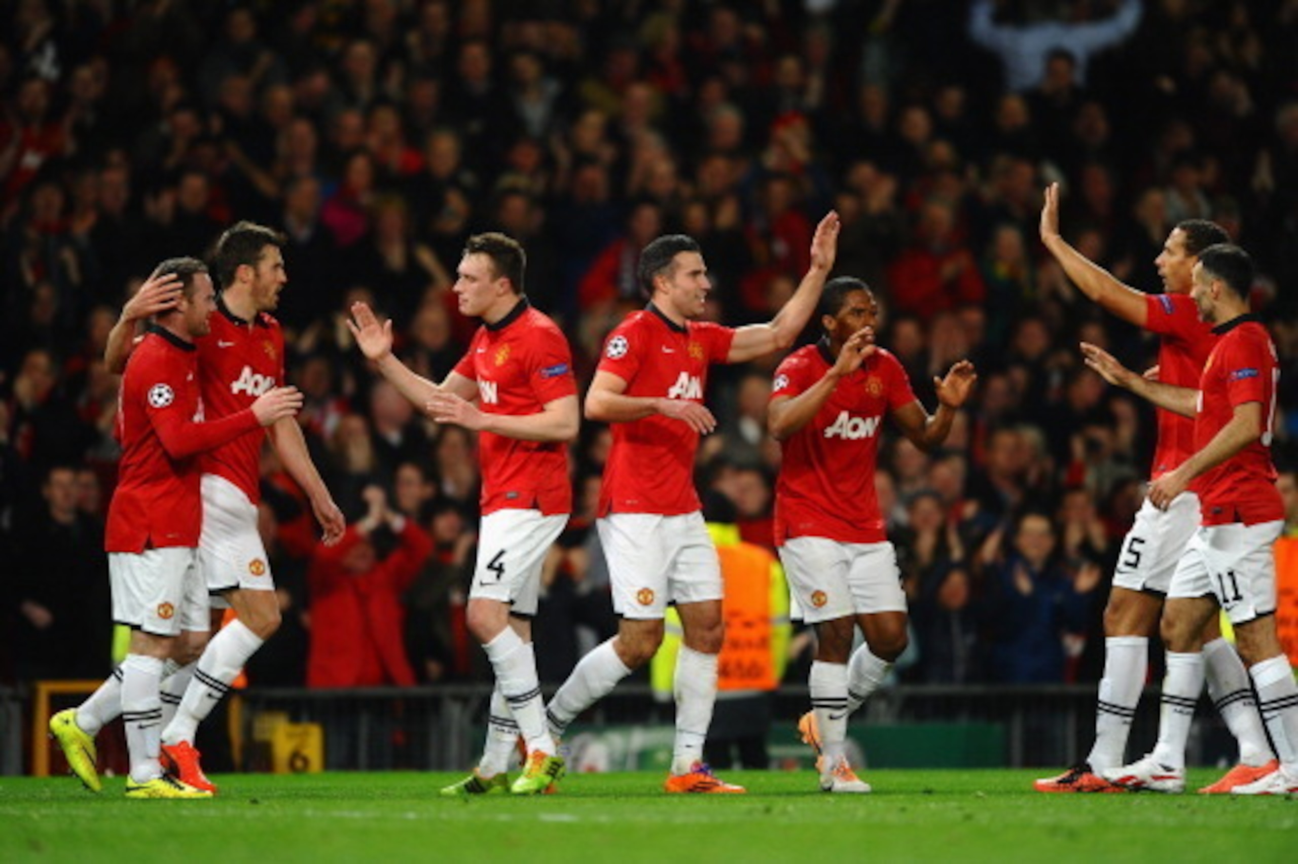 MANCHESTER, ENGLAND - MARCH 19:  Robin van Persie of Manchester United celebrates scoring the second goal with his team-mates during the UEFA Champions League Round of 16 second round match between Manchester United and Olympiacos FC at Old Trafford on Ma