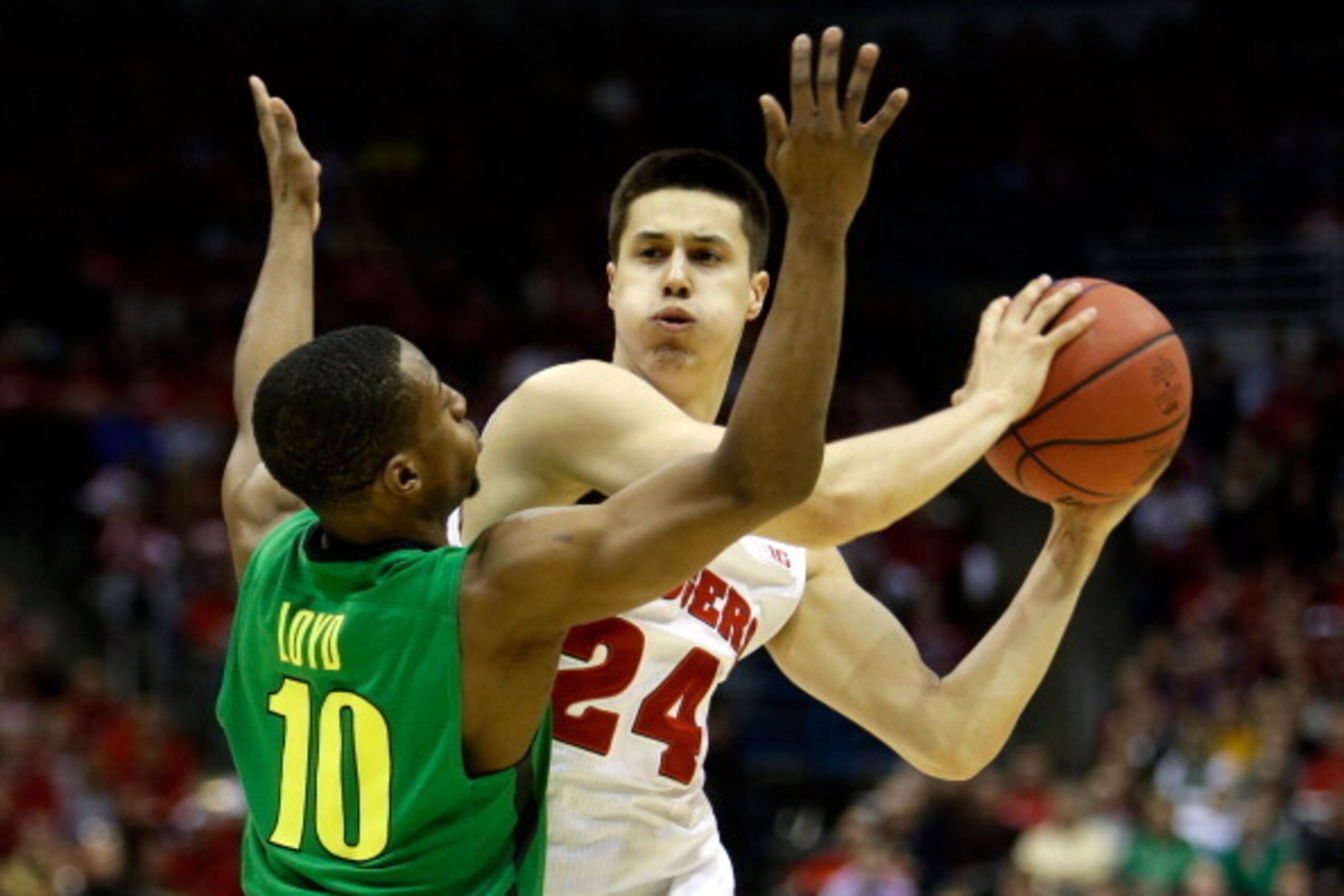MILWAUKEE, WI - MARCH 22:  Bronson Koenig #24 of the Wisconsin Badgers looks to pass the ball against Johnathan Loyd #10 of the Oregon Ducks during the third round of the 2014 NCAA Men's Basketball Tournament at BMO Harris Bradley Center on March 22, 2014