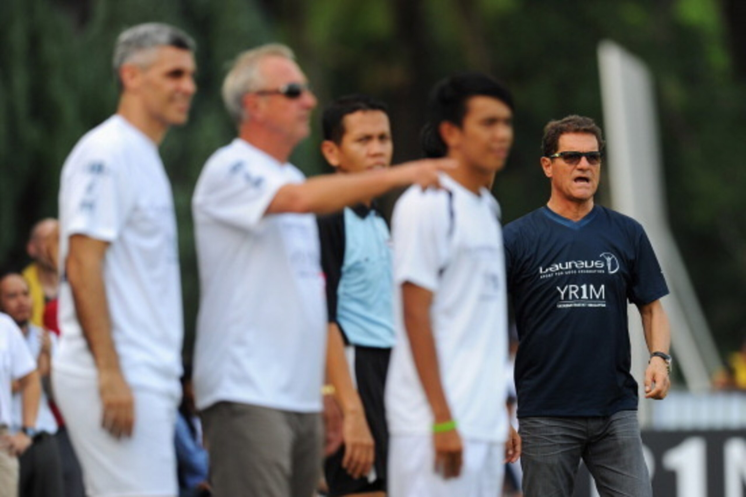KUALA LUMPUR, MALAYSIA - MARCH 25:  Johan Cruyff coach of Team YR1M  and Fabio Capello coach of Team Laureus look on from the touchline during the Laureus All Stars Unity Cup ahead of the 2014 Laureus World Sports Awards at Royal Selangor Club on March 25