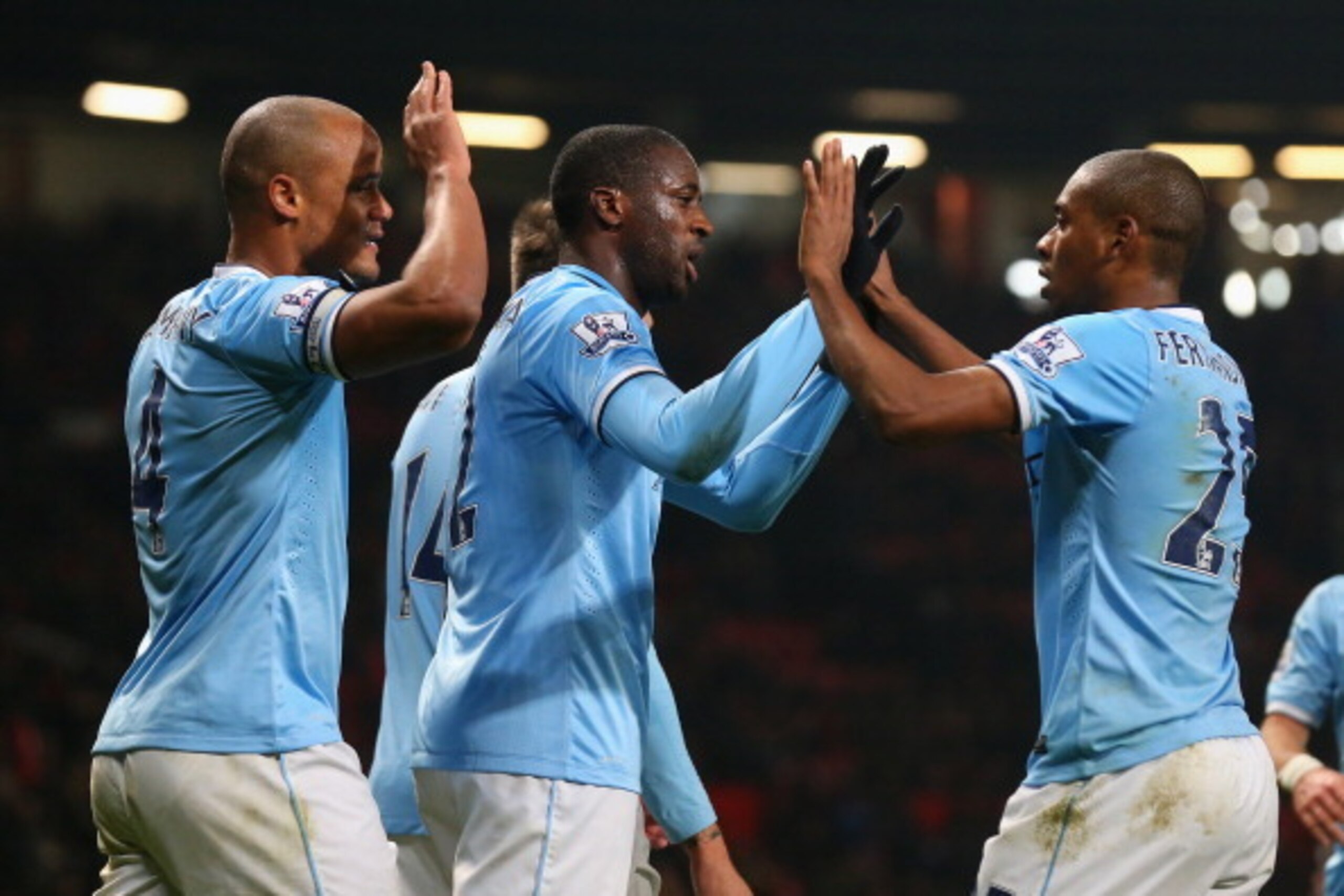 MANCHESTER, ENGLAND - MARCH 25:  Yaya Toure of Manchester City celebrates scoring the third goal with his team-mates Fernandinho and Vincent Kompany (L) during the Barclays Premier League match between Manchester United and Manchester City at Old Trafford