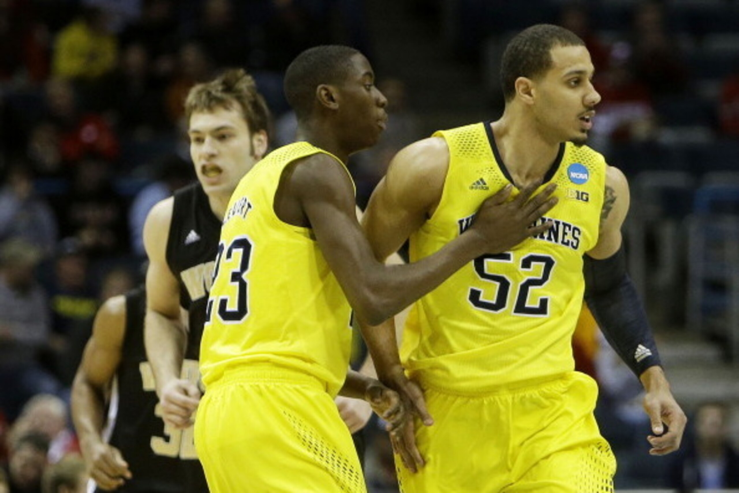 MILWAUKEE, WI - MARCH 20:  Jordan Morgan #52 celebrates his dunk against the Wofford Terriers in the first half with Caris LeVert #23 of the Michigan Wolverines during the second round of the 2014 NCAA Men's Basketball Tournament at BMO Harris Bradley Cen