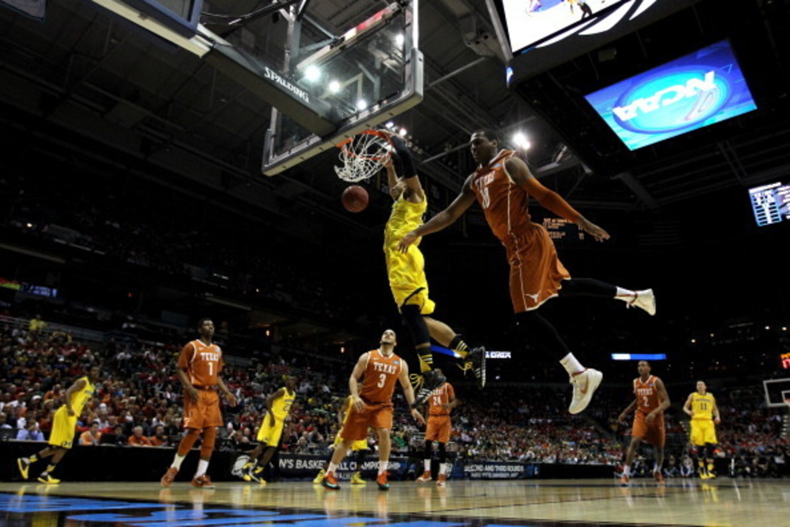 MILWAUKEE, WI - MARCH 22:  Jordan Morgan #52 of the Michigan Wolverines dunks the ball against Cameron Ridley #55 of the Texas Longhorns during the third round of the 2014 NCAA Men's Basketball Tournament at BMO Harris Bradley Center on March 22, 2014 in 