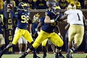 Sep 7, 2013; Ann Arbor, MI, USA; Michigan Wolverines quarterback Devin Gardner (98) throws the ball while offensive linesman Graham Glasgow (61) blocks Notre Dame Fighting Irish defensive lineman Louis Nix III (1) in the first quarter at Michigan Stadium.