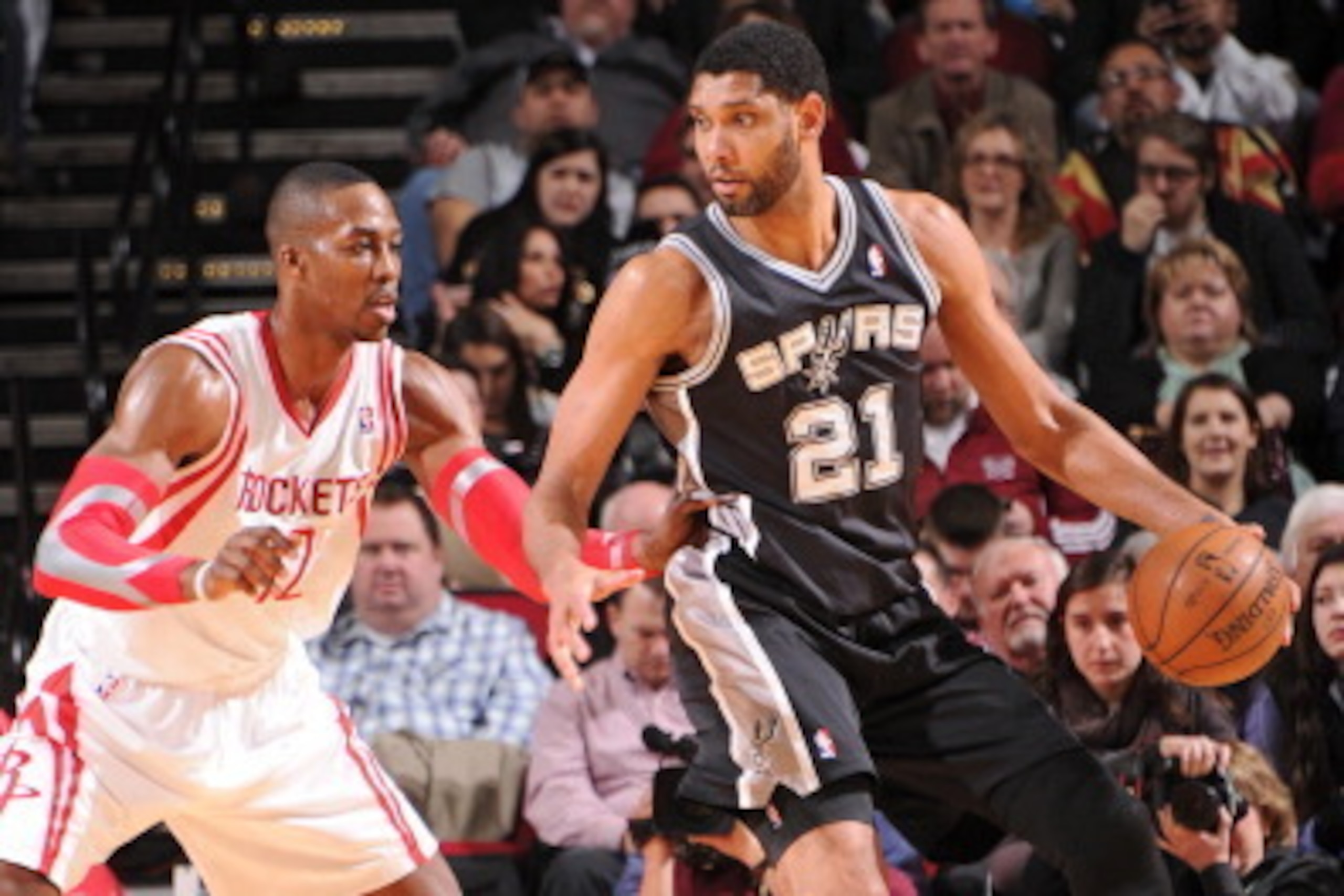HOUSTON, TX - JANUARY 28:  Tim Duncan #21 of the San Antonio Spurs handles the ball against Dwight Howard #12 of the Houston Rockets on January 28, 2014 at the Toyota Center in Houston, Texas. NOTE TO USER: User expressly acknowledges and agrees that, by 
