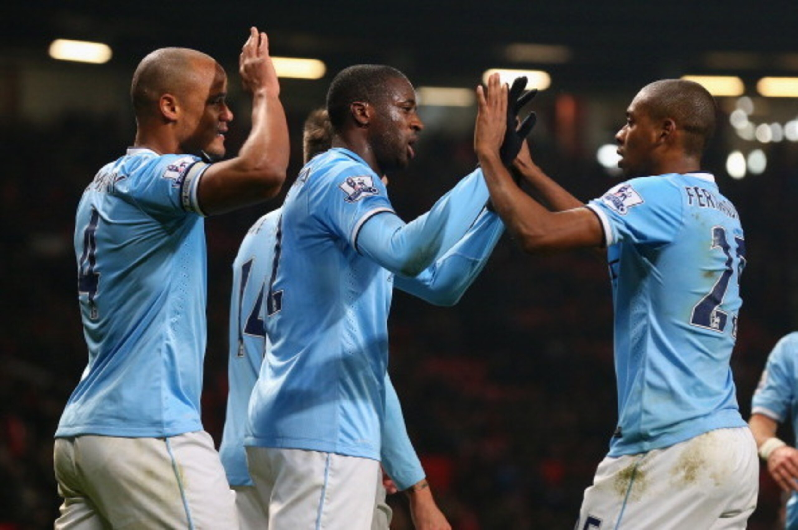 MANCHESTER, ENGLAND - MARCH 25: Yaya Toure of Manchester City celebrates scoring the third goal with his team-mates Fernandinho and Vincent Kompany (L) during the Barclays Premier League match between Manchester United and Manchester City at Old Trafford MANCHESTER, ENGLAND - MARCH 25: Yaya Toure of Manchester City celebrates scoring the third goal with his team-mates Fernandinho and Vincent Kompany (L) during the Barclays Premier League match between Manchester United and Manchester City at Old Trafford