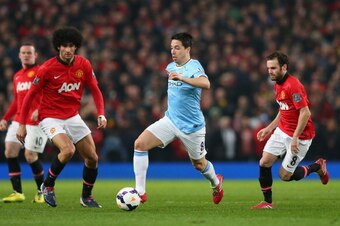 MANCHESTER, ENGLAND - MARCH 25:  Samir Nasri of Manchester City competes with Marouane Fellaini and Juan Mata (R) of Manchester United during the Barclays Premier League match between Manchester United and Manchester City at Old Trafford on March 25, 2014