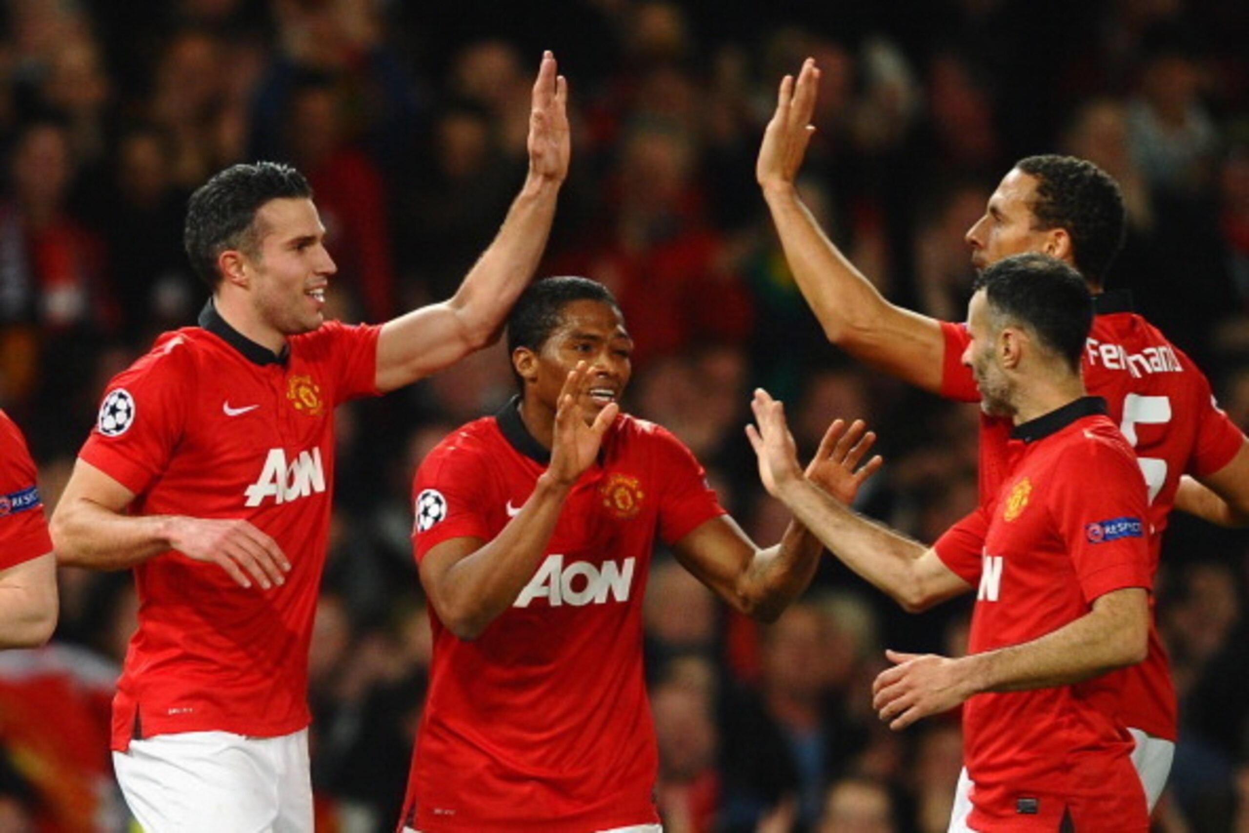 MANCHESTER, ENGLAND - MARCH 19:  Robin van Persie of Manchester United celebrates scoring the second goal with his team-mates during the UEFA Champions League Round of 16 second round match between Manchester United and Olympiacos FC at Old Trafford on Ma