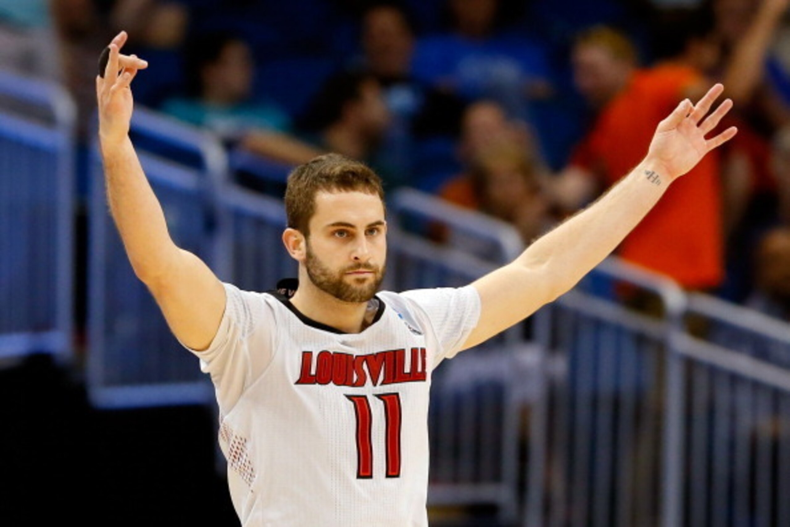 ORLANDO, FL - MARCH 20:  Luke Hancock #11 of the Louisville Cardinals celebrates after his second three point in the second half against the Manhattan Jaspers during the second round of the 2014 NCAA Men's Basketball Tournament at Amway Center on March 20