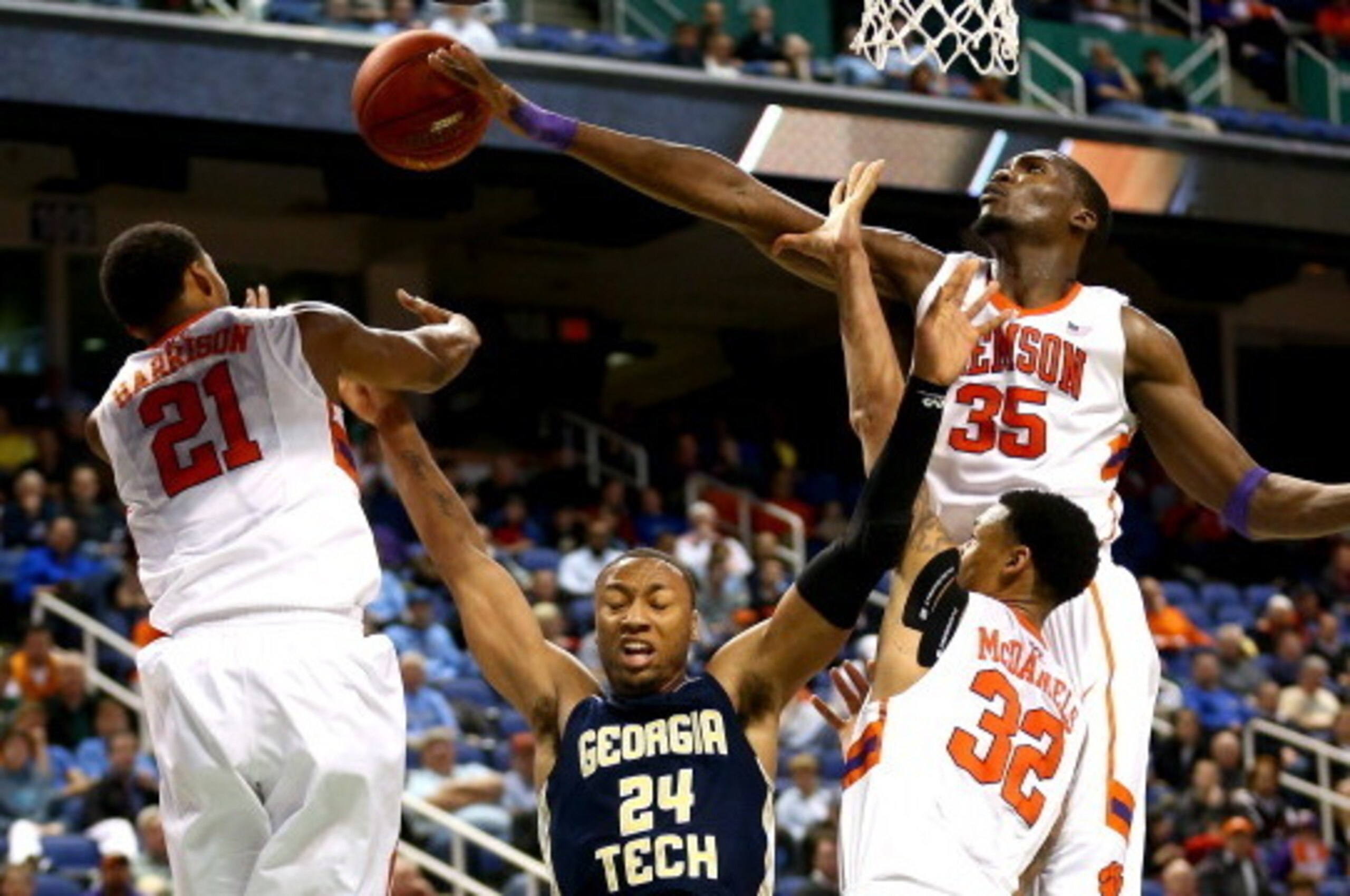 GREENSBORO, NC - MARCH 13:  Kammeon Holsey #24 of the Georgia Tech Yellow Jackets is hit by teammates Damarcus Harrison #21, K.J. McDaniels #32 and Landry Nnoko #35 of the Clemson Tigers during the second round of the 2014 Men's ACC Basketball Tournament 