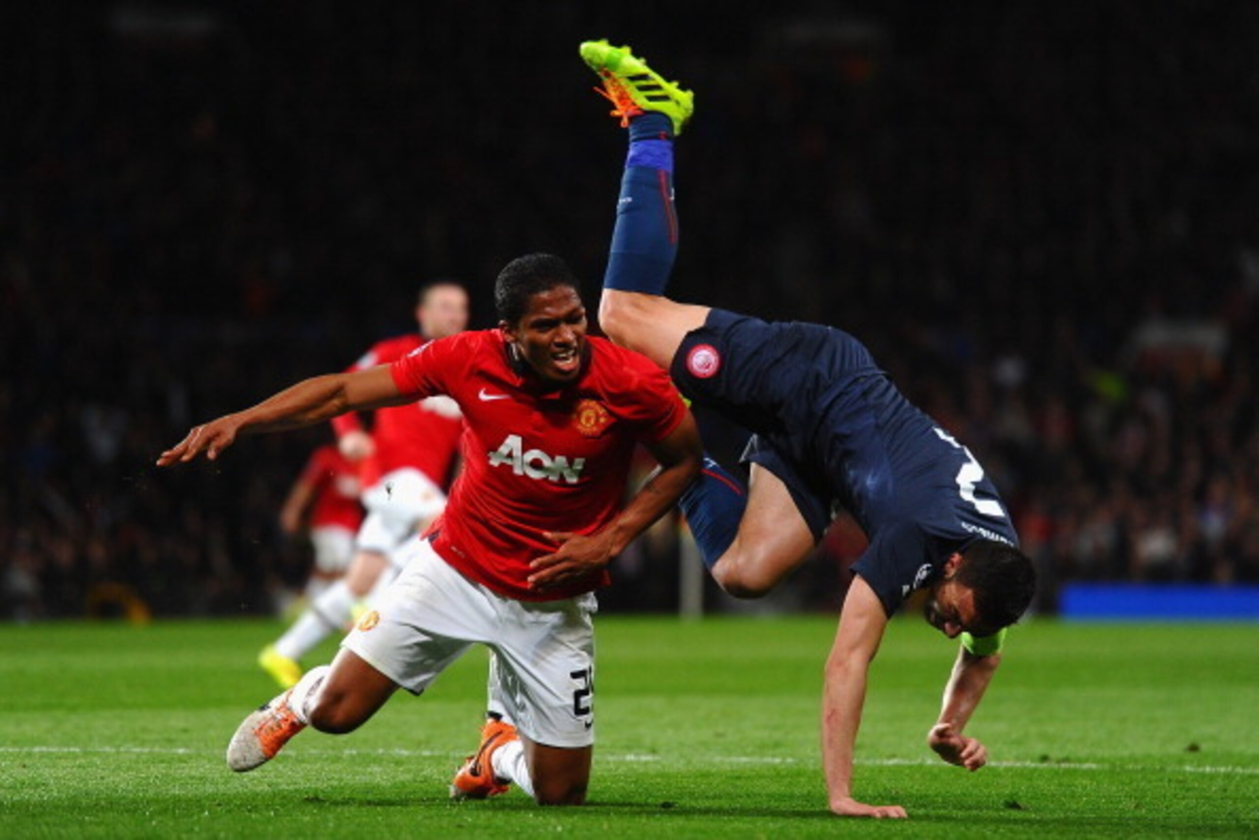 MANCHESTER, ENGLAND - MARCH 19:  Antonio Valencia of Manchester United tangles with Giannis Maniatis of Olympiacos during the UEFA Champions League Round of 16 second round match between Manchester United and Olympiacos FC at Old Trafford on March 19, 201