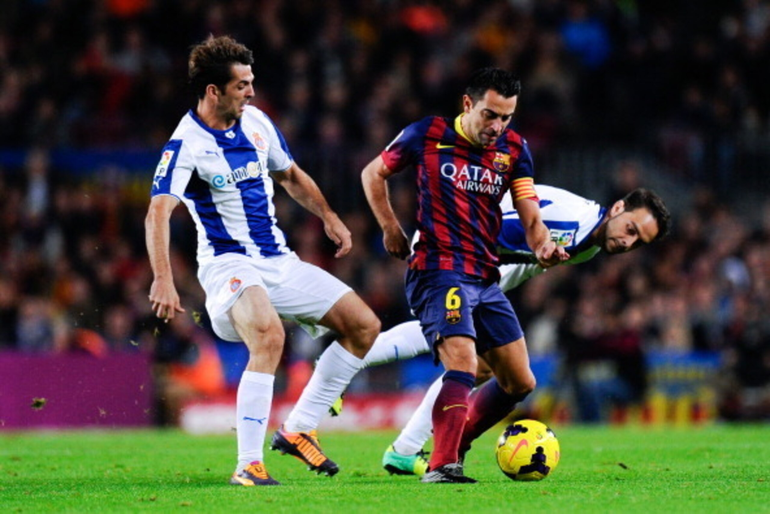 BARCELONA, SPAIN - NOVEMBER 01:  Xavi Hernandez of FC Barcelona duels for the ball with Victor Sanchez (L) and Sergio Garcia of RCD Espanyol during the La Liga match between FC Barcelona and RCD Espanyol at Camp Nou on November 1, 2013 in Barcelona, Spain