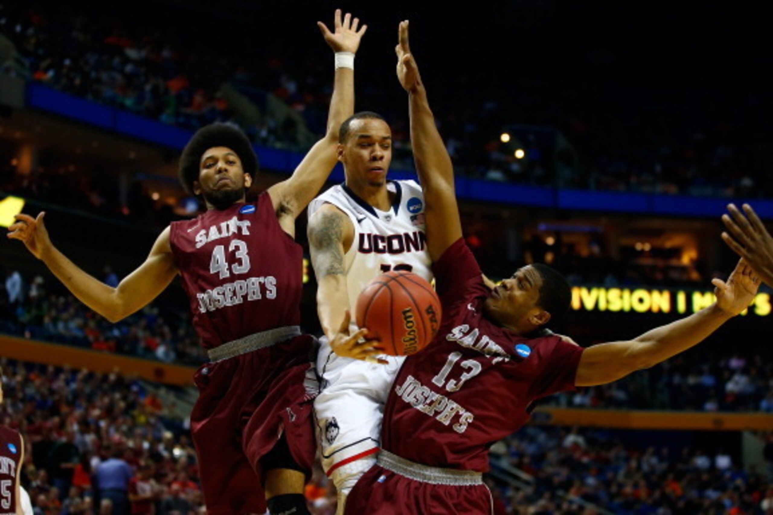 BUFFALO, NY - MARCH 20: Shabazz Napier #13 of the Connecticut Huskies goes to the basket as DeAndre Bembry #43 and Ronald Roberts, Jr. #13 of the Saint Joseph's Hawks defend during the second round of the 2014 NCAA Men's Basketball Tournament at the First
