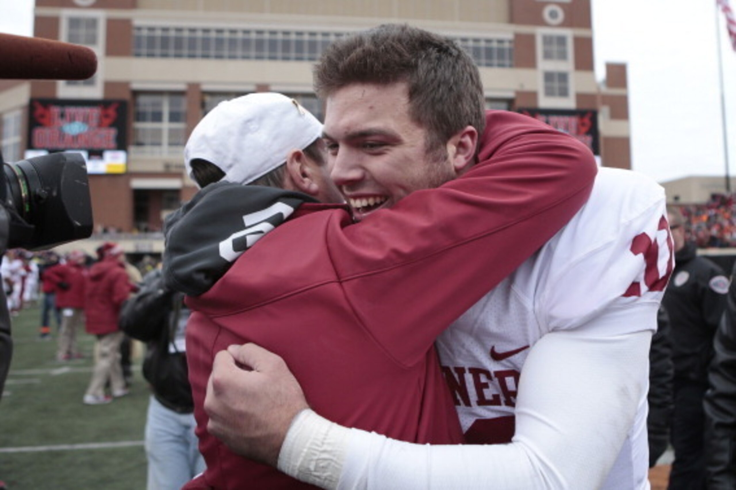 STILLWATER, OK - DECEMBER 7:  Quarterback Blake Bell #10 hugs head coach Bob Stoops of the Oklahoma Sooners after the game against the Oklahoma State Cowboys December 7, 2013 at Boone Pickens Stadium in Stillwater, Oklahoma. Oklahoma defeated Oklahoma Sta